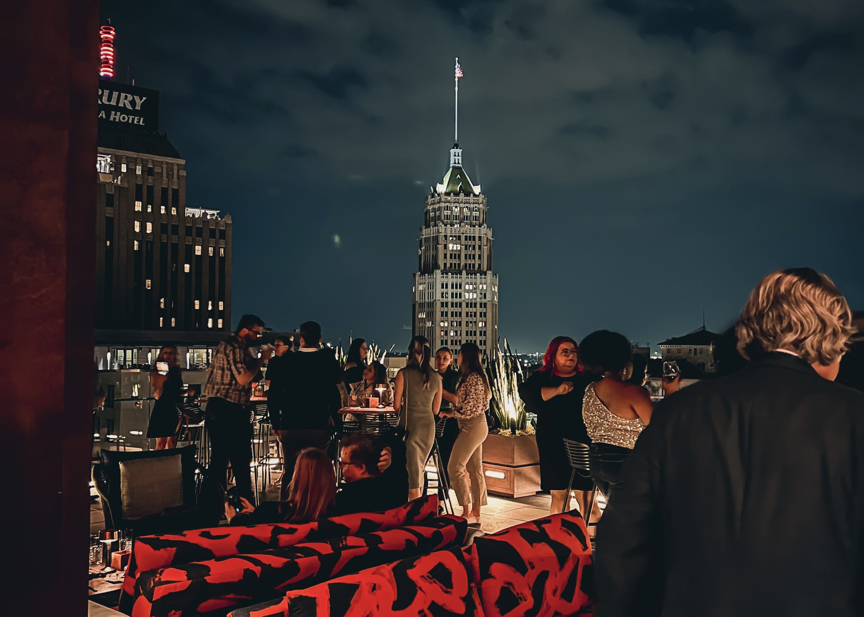 People gather on a rooftop bar overlooking the Tower Life building. 