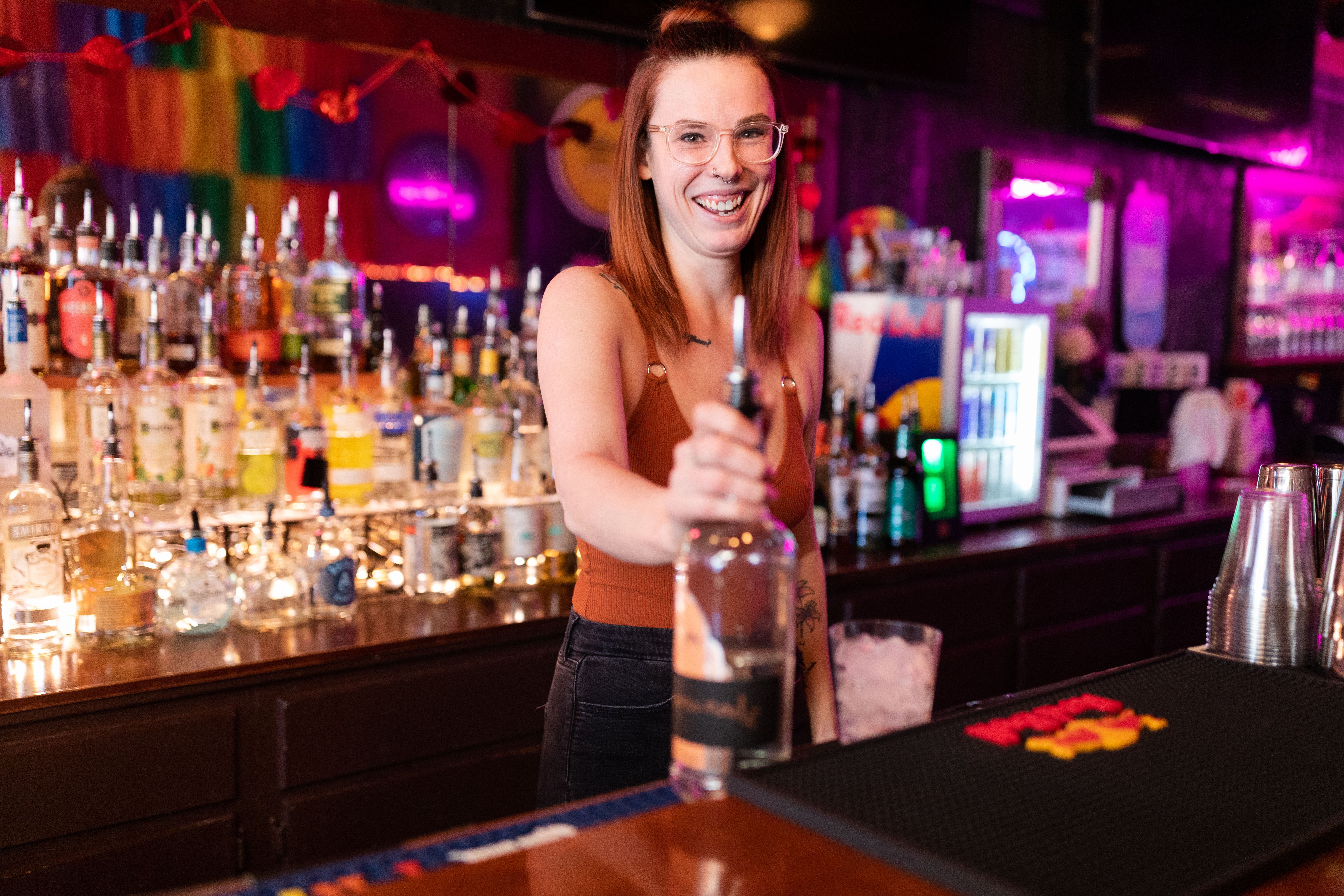 Slammers head bartender Madi Blakeman laughs while preparing to pour liquor into a glass