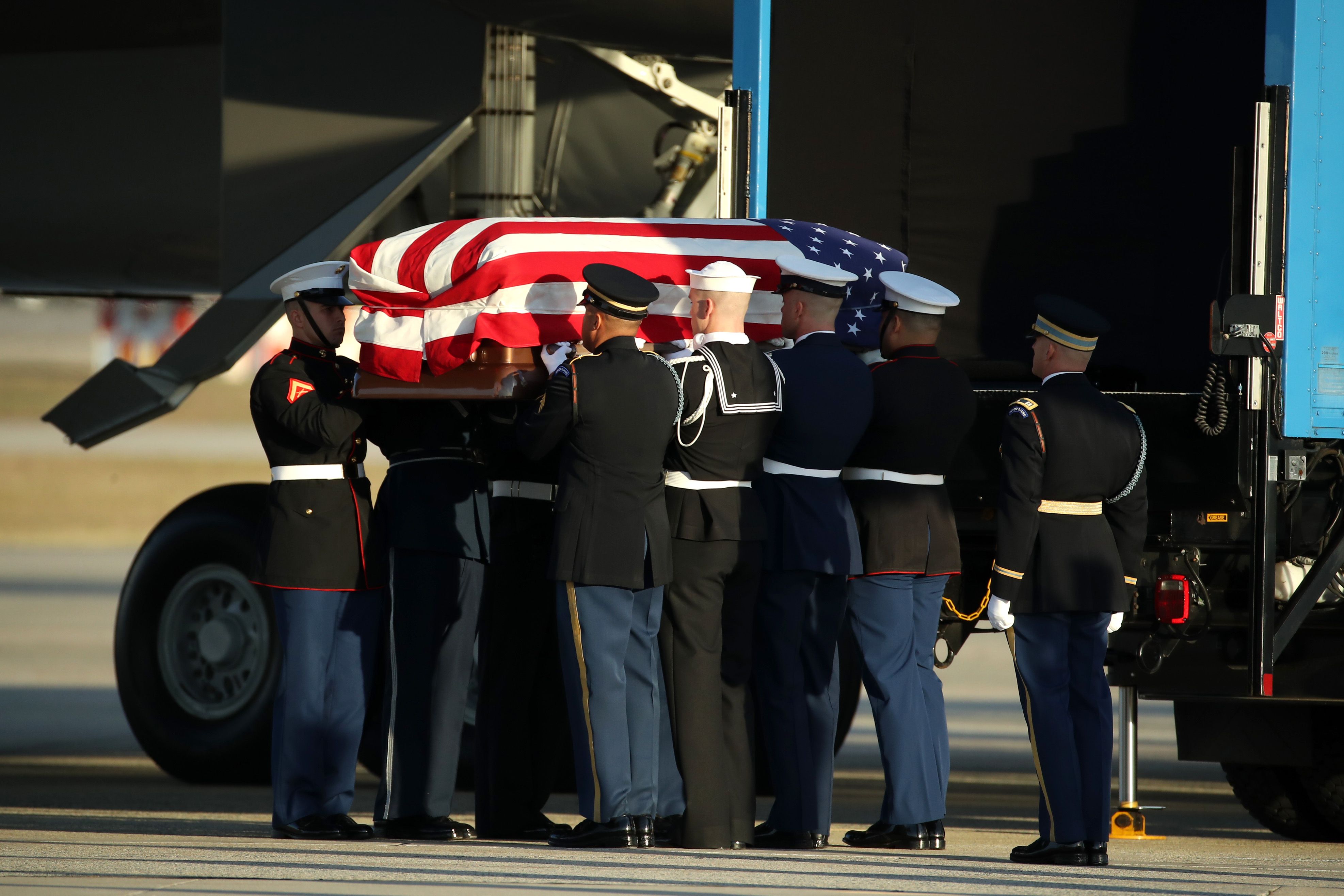 George H. W. Bush's casket carried as 21-gun salute sounded.