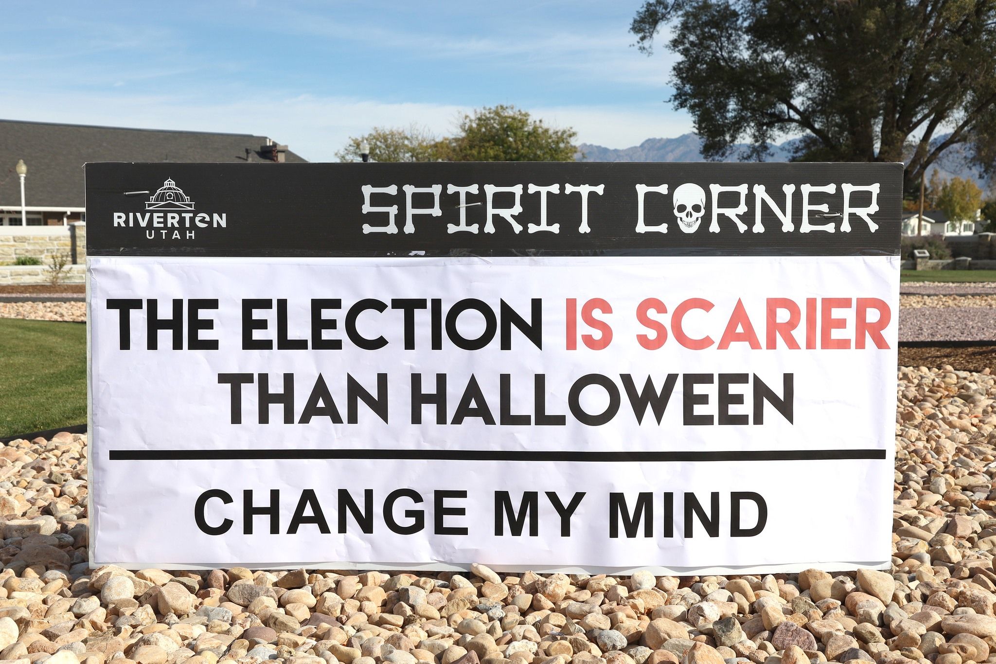 A sign reads "The election is scarier than Halloween. Change my mind."