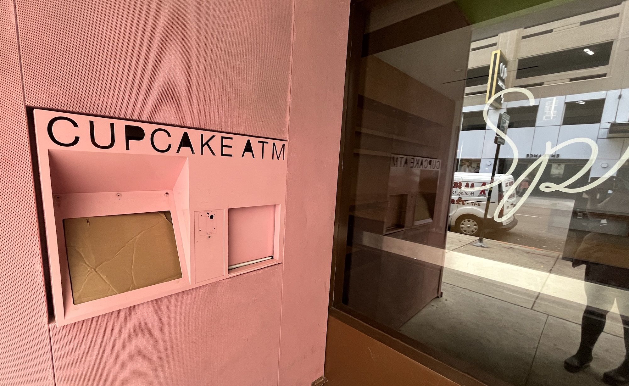 A pink wall with an ATM machine boarded up that reads Cupcake ATM.