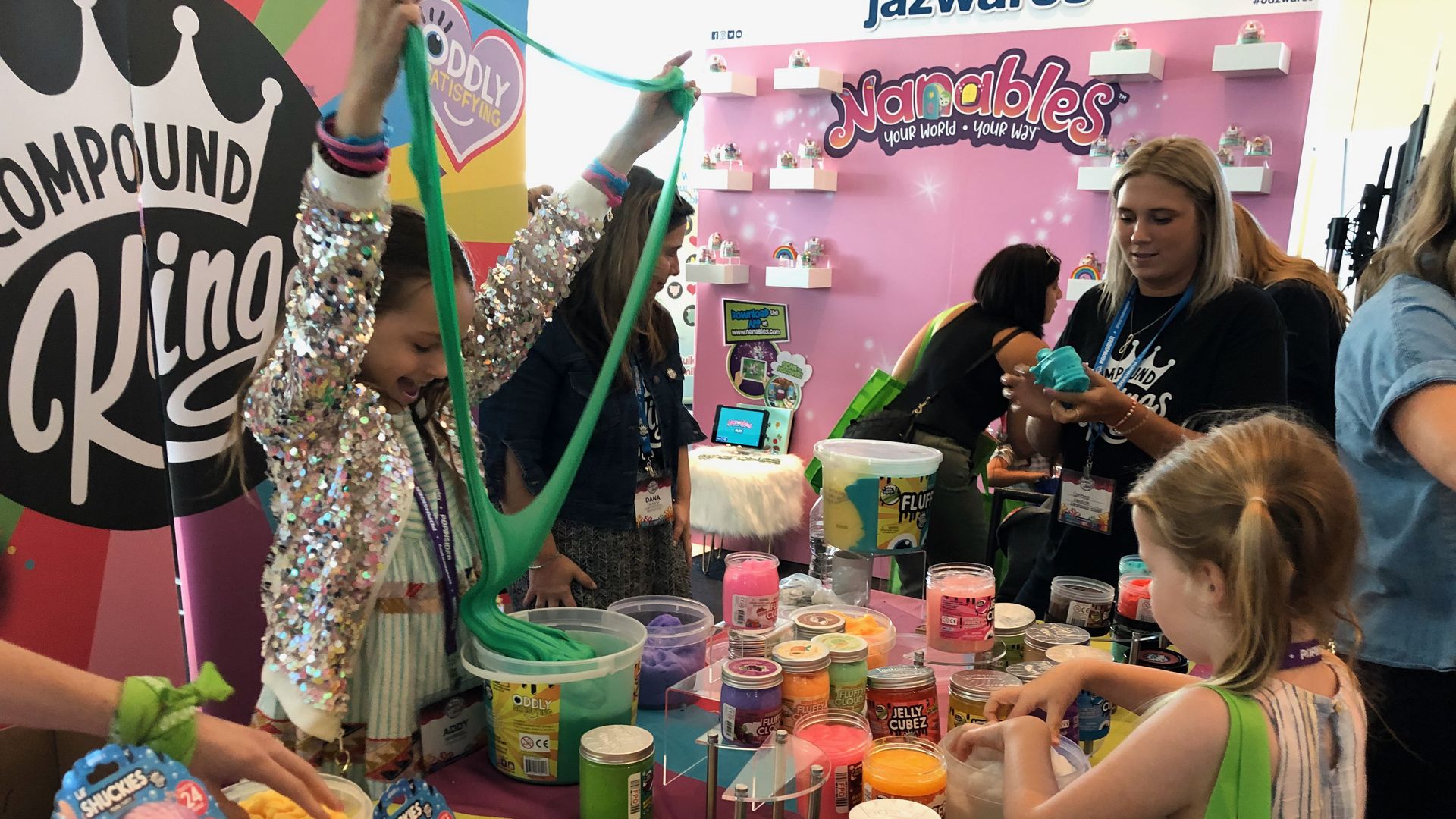 Children playing with slime toys at an industry trade show.