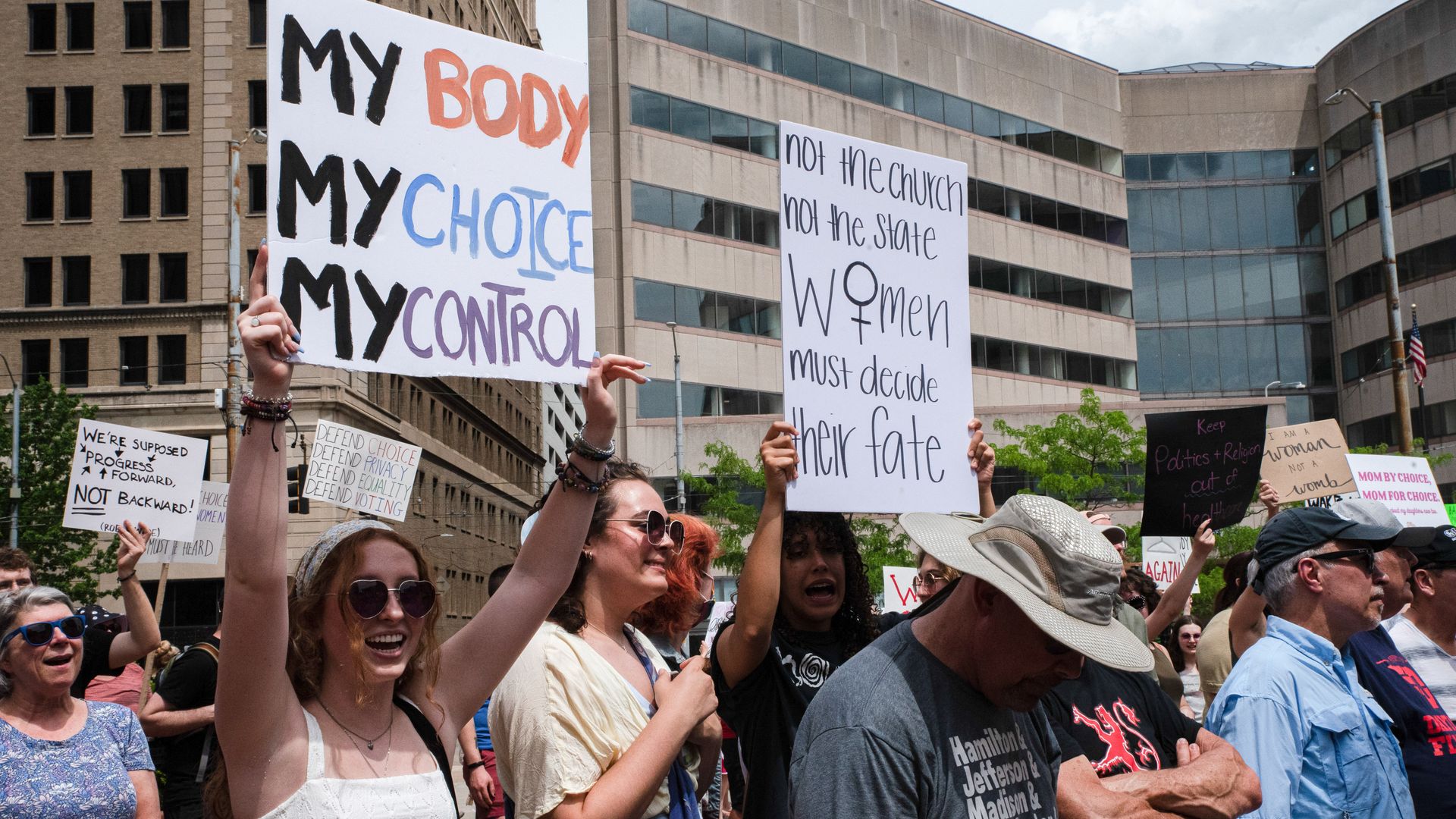 Pro-choice activists hold signs reading "My Body My Choice My Control" and "Not the church, not the state, women must decide their fate."