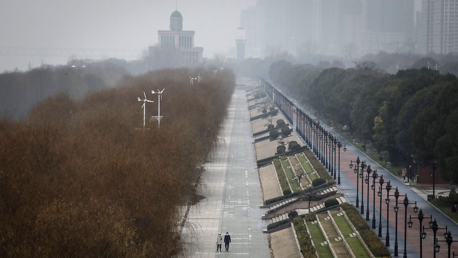 Two lone pedestrians walking in deserted aerial view of Jiangtan Park in Wuhan, China