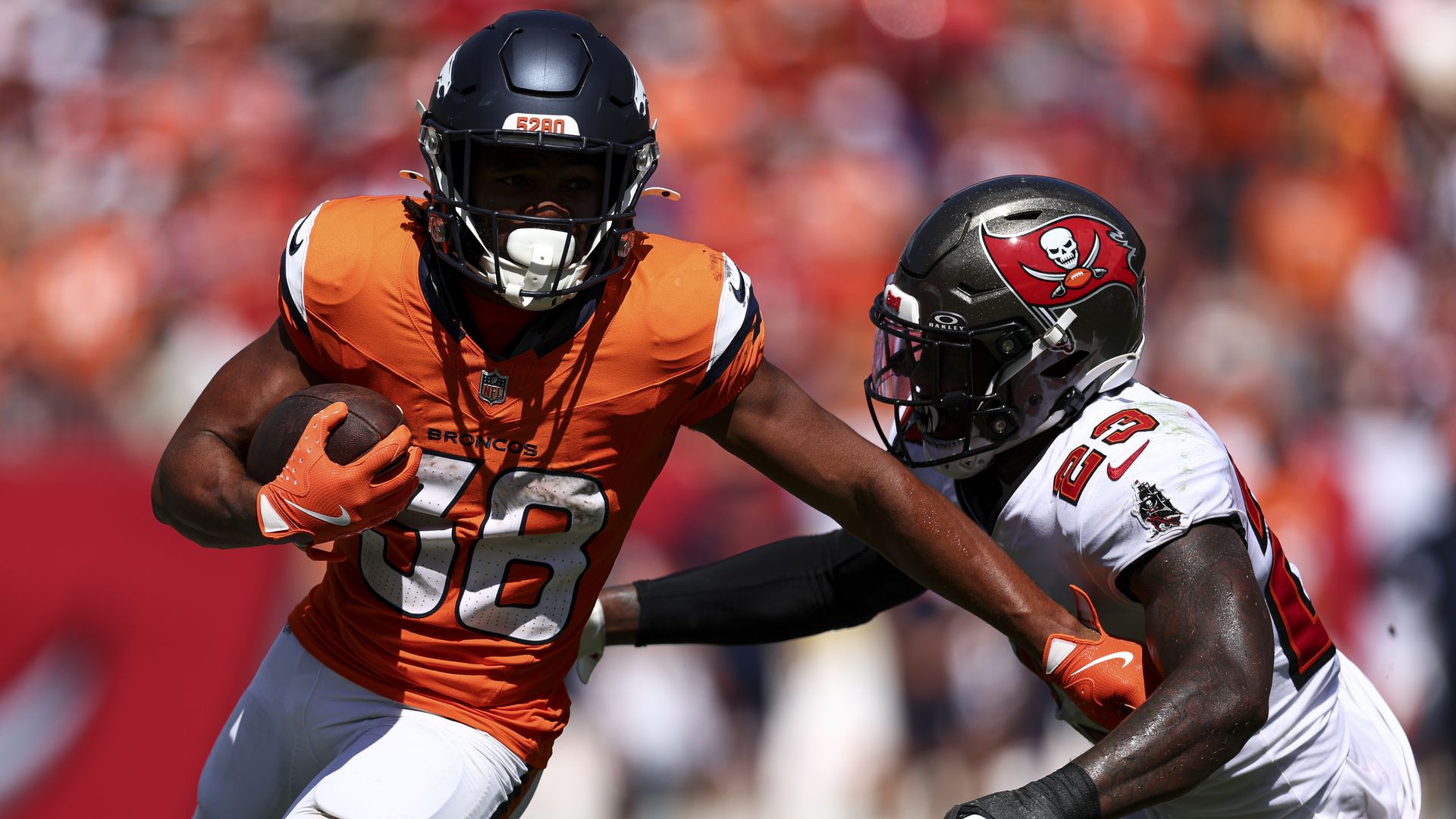 A man in a helmet in an orange jersey. 