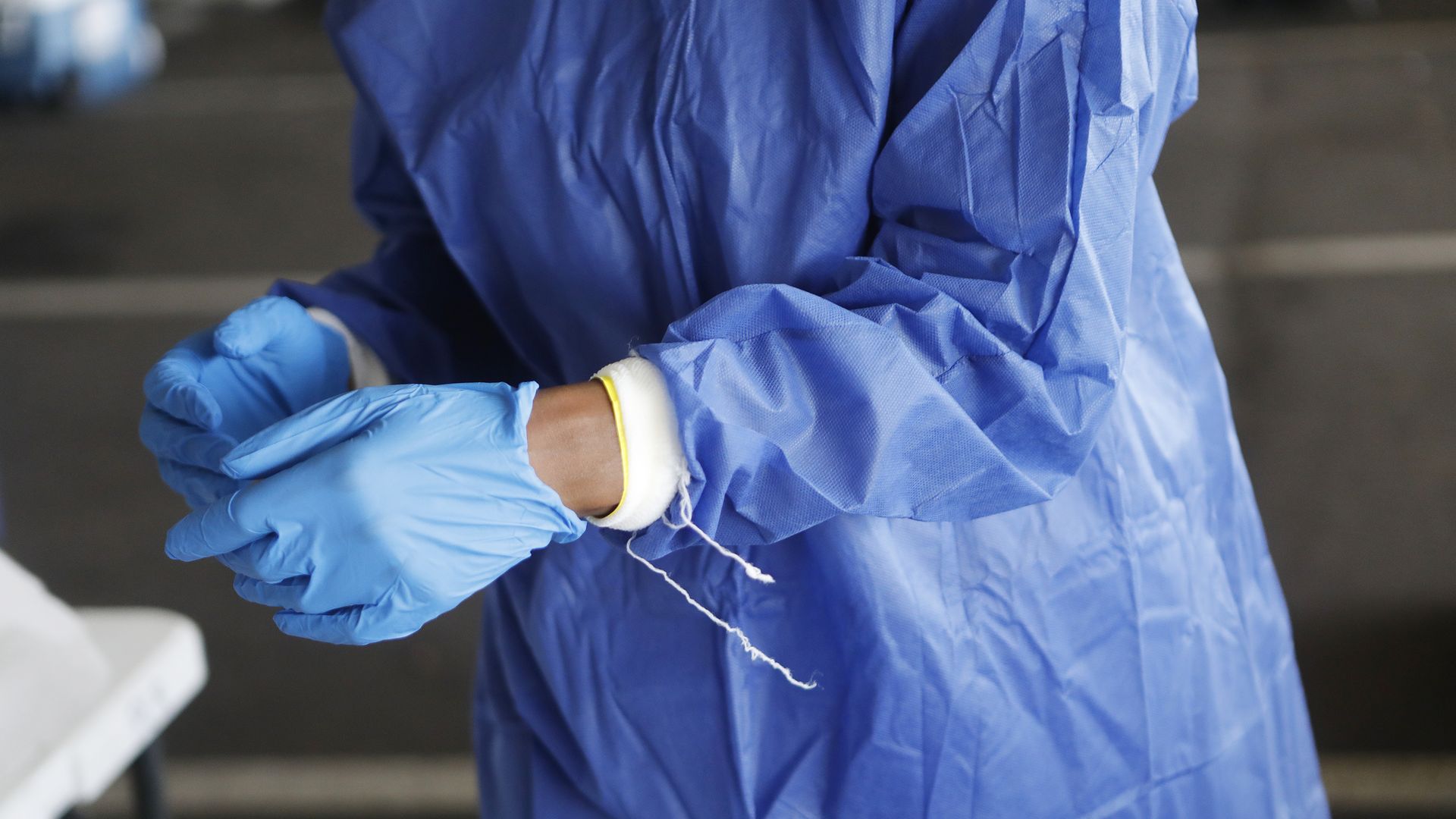 A nurse removes her gloves after a shift.