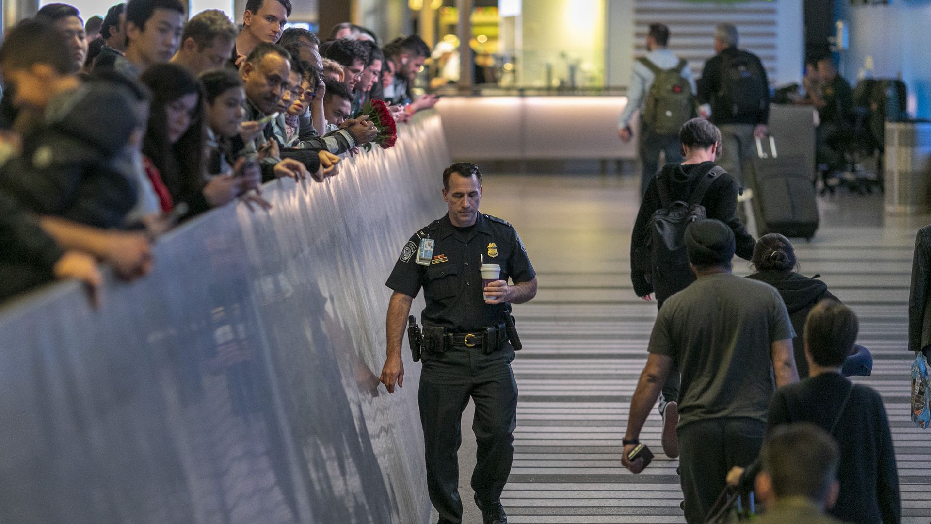 Security officer at LAX airport where flight passengers wait to be screened for the Wuhan coronavirus