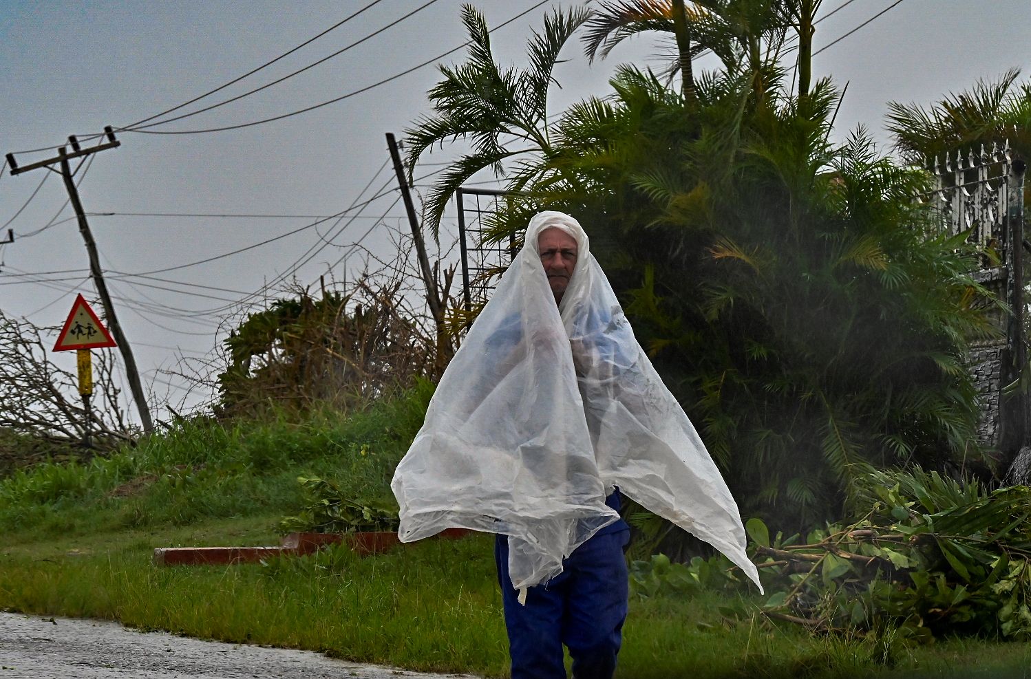 man walks through a street during Hurricane Ian
