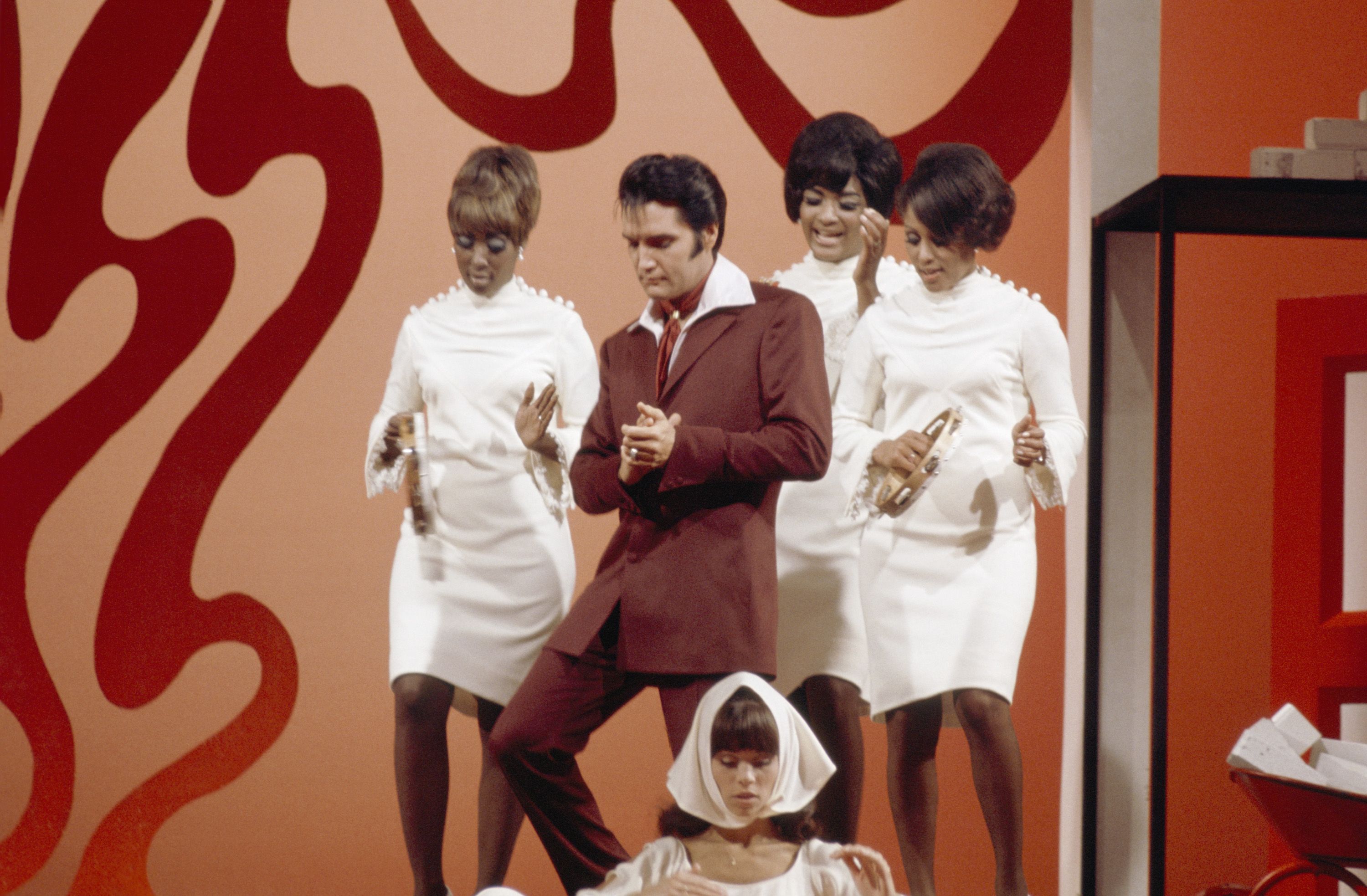 Elvis Presley during a performance with three Black backup dancers at NBC Studios in Burbank.