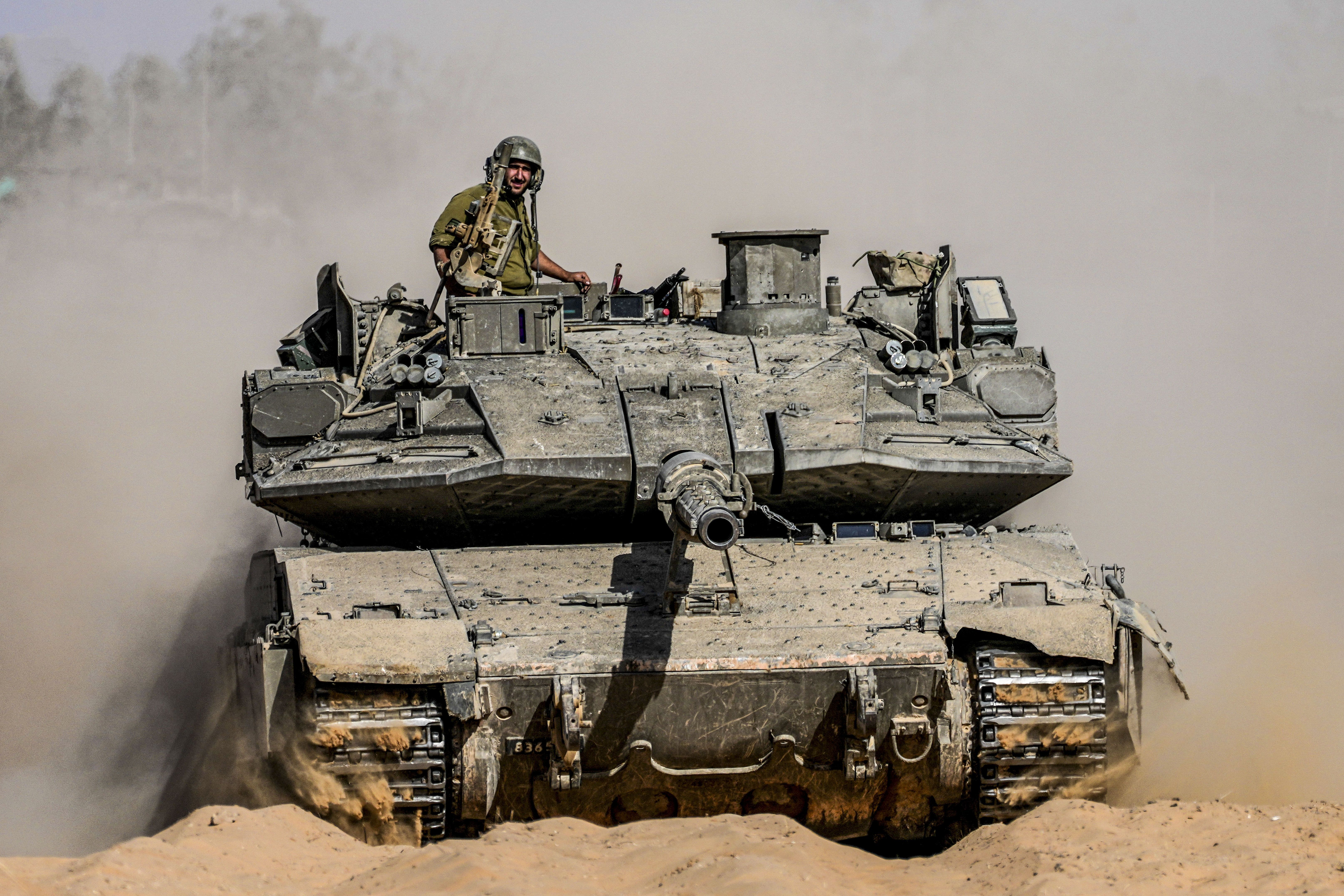Israeli soldiers drive a tank at a staging ground near the border with the Gaza Strip yesterday.