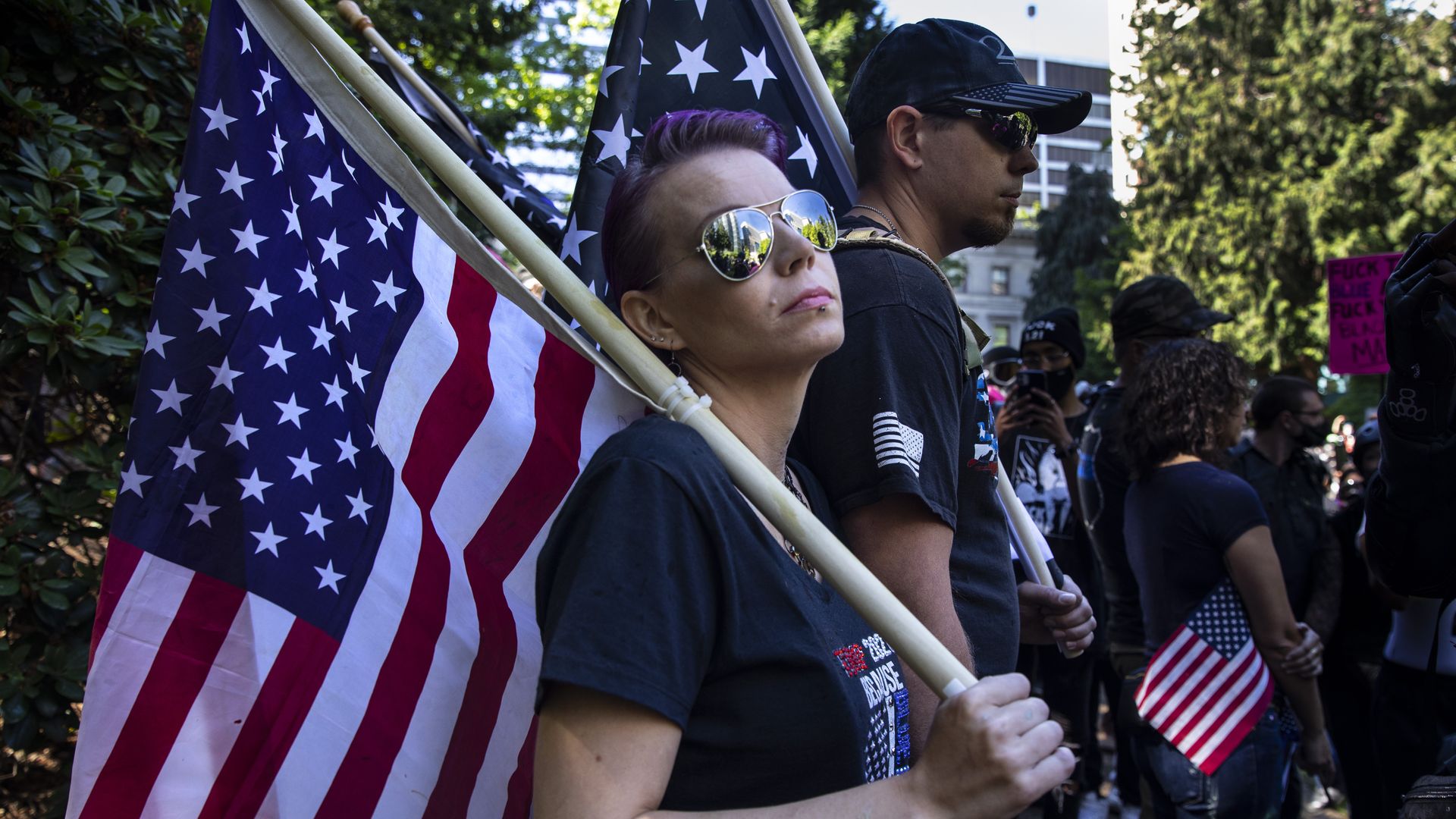 Protesters carry flags at a rally between the far-right Proud Boy and Black Lives Matter protesters in Portland, Oregon on August 22