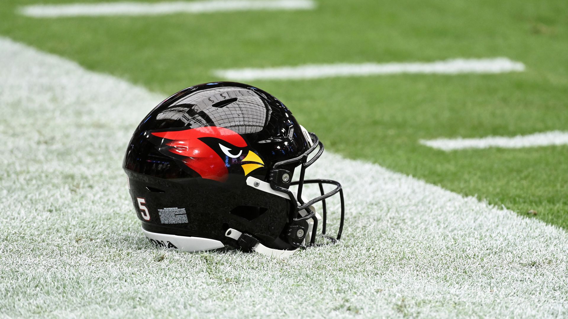 A Cardinals NFL helmet sitting on a sideline.