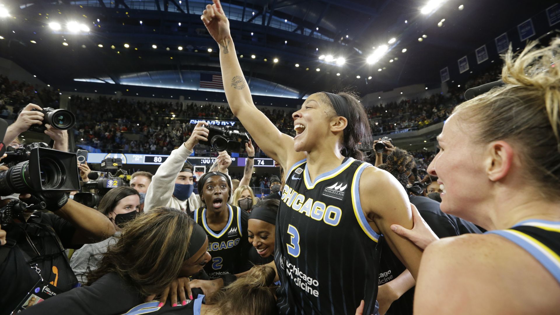 Photo of a woman celebrating on the court after winning a basketball championship.