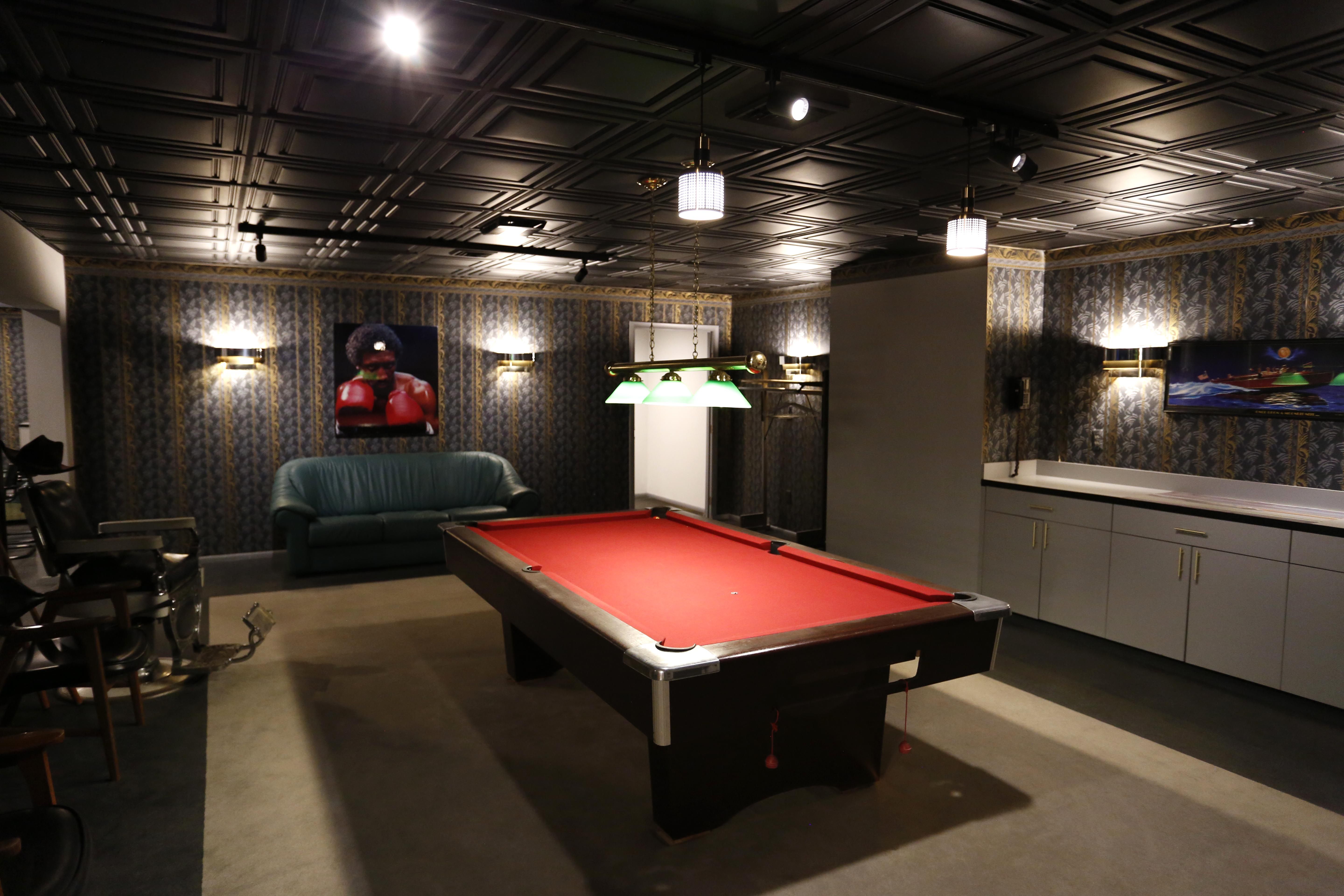 The green room has a pool table and unique wallpaper.