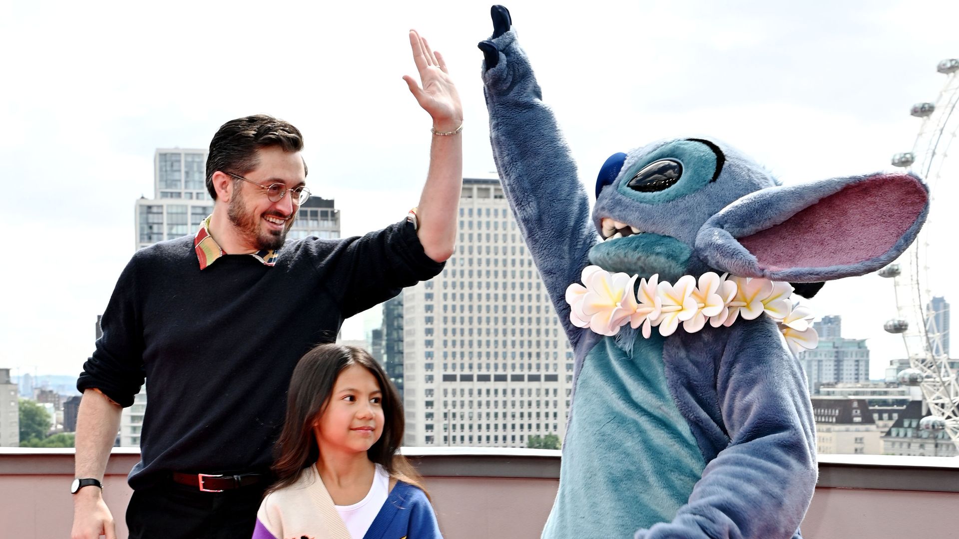 a person high fiving a life-sized stitch