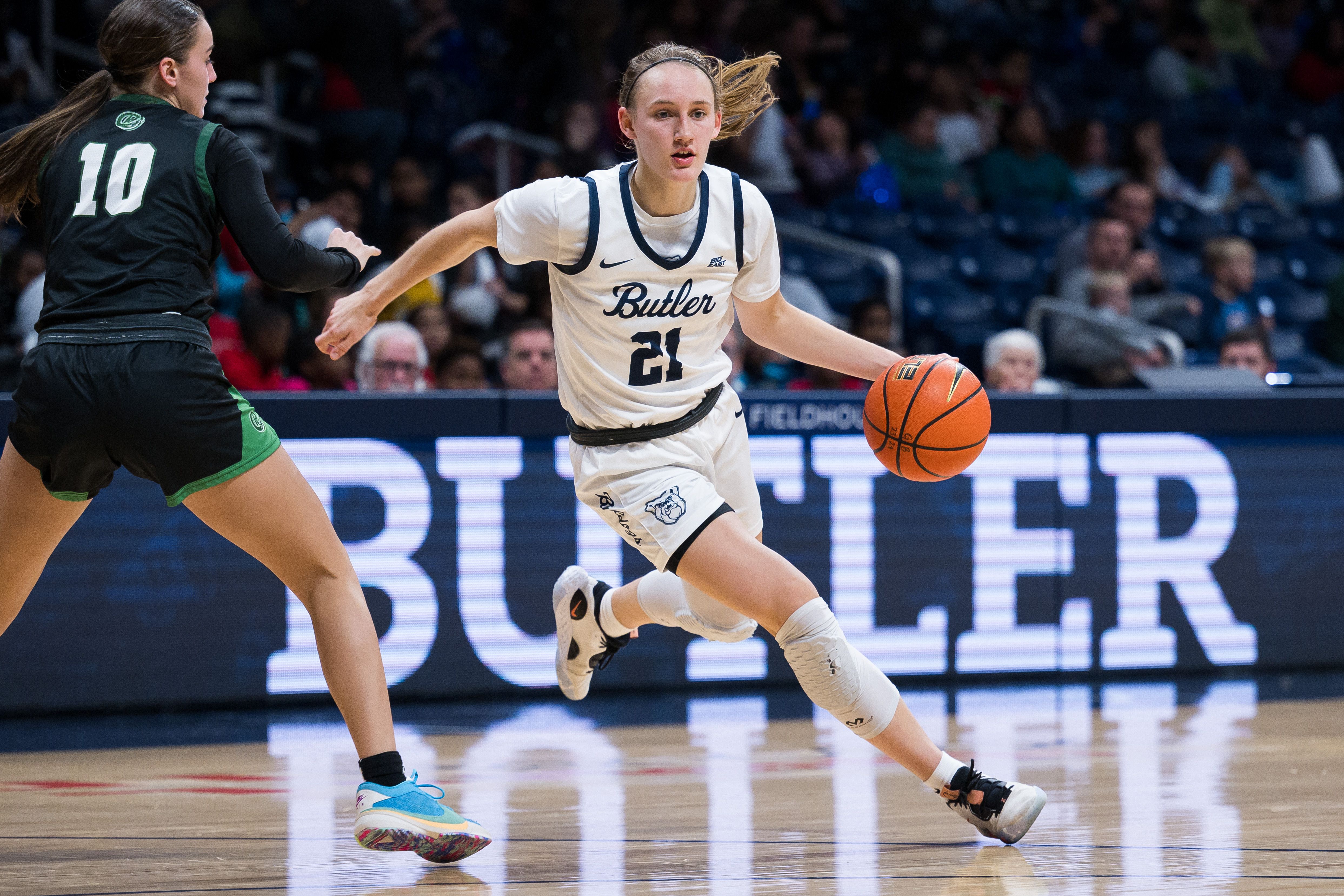 Photo of a woman dribbling a basketball on the court