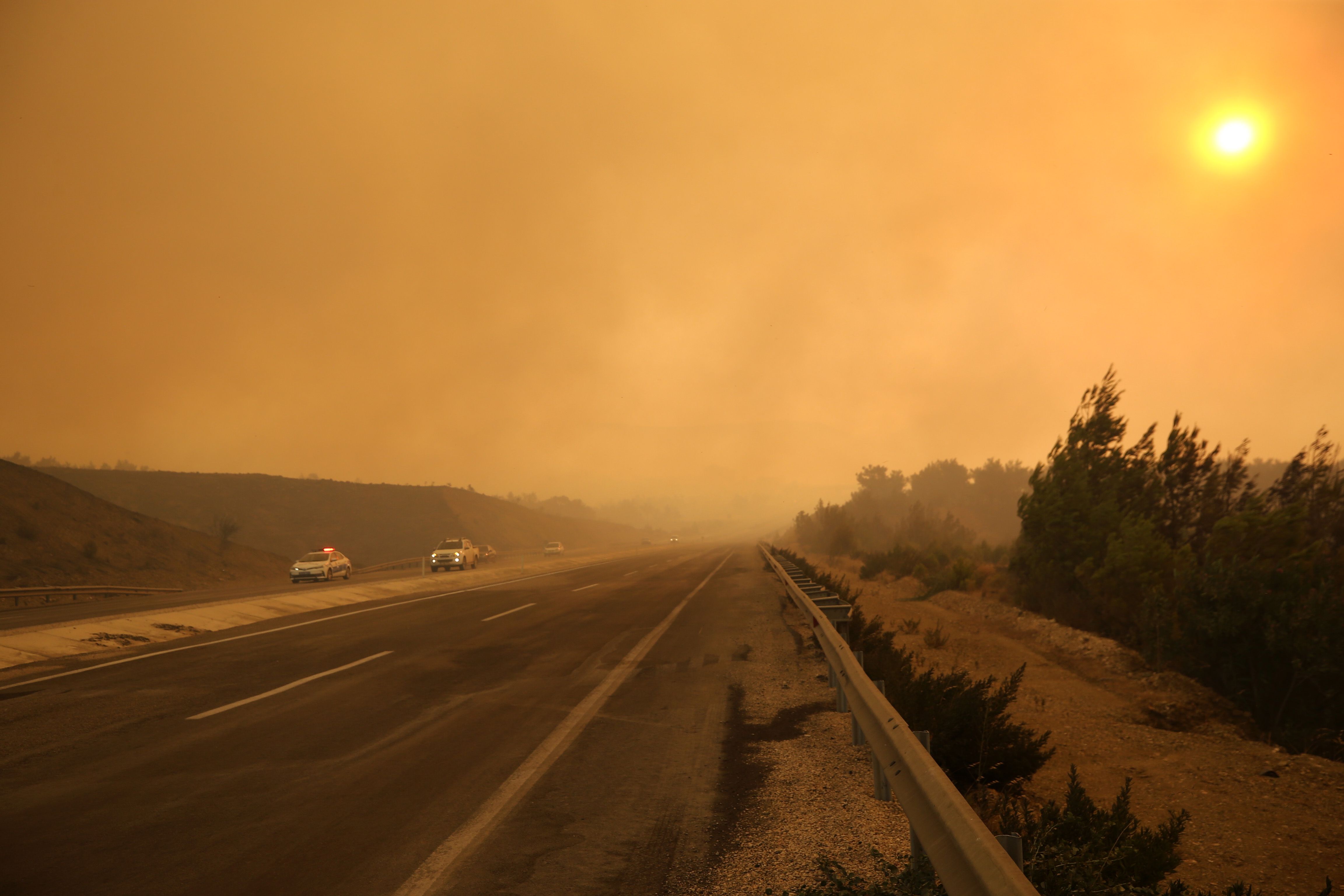 Cars move on the highway as smoke reduced visibility distance during the fire July 30