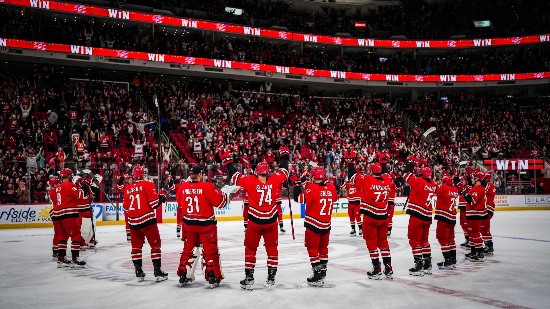In red jerseys at center ice, the Carolina Hurricanes celebrate a win at the Lenovo Center  in Raleigh.
