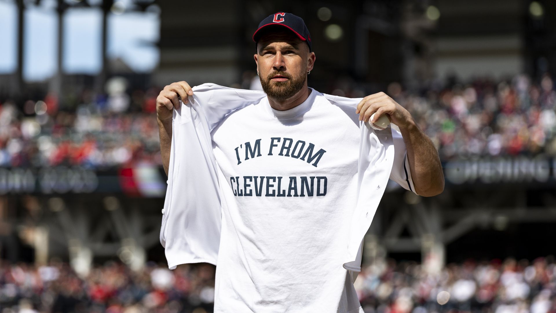 Travis Kelce reveals an "I'm From Cleveland" shirt on the mound at the Cleveland Guardians game. 