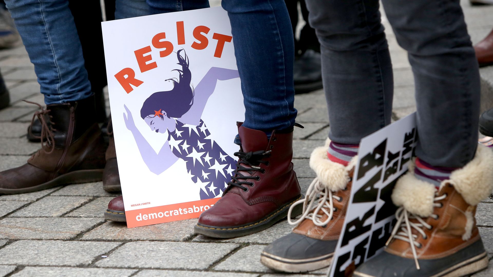 A sign on the ground that says "Resist" 