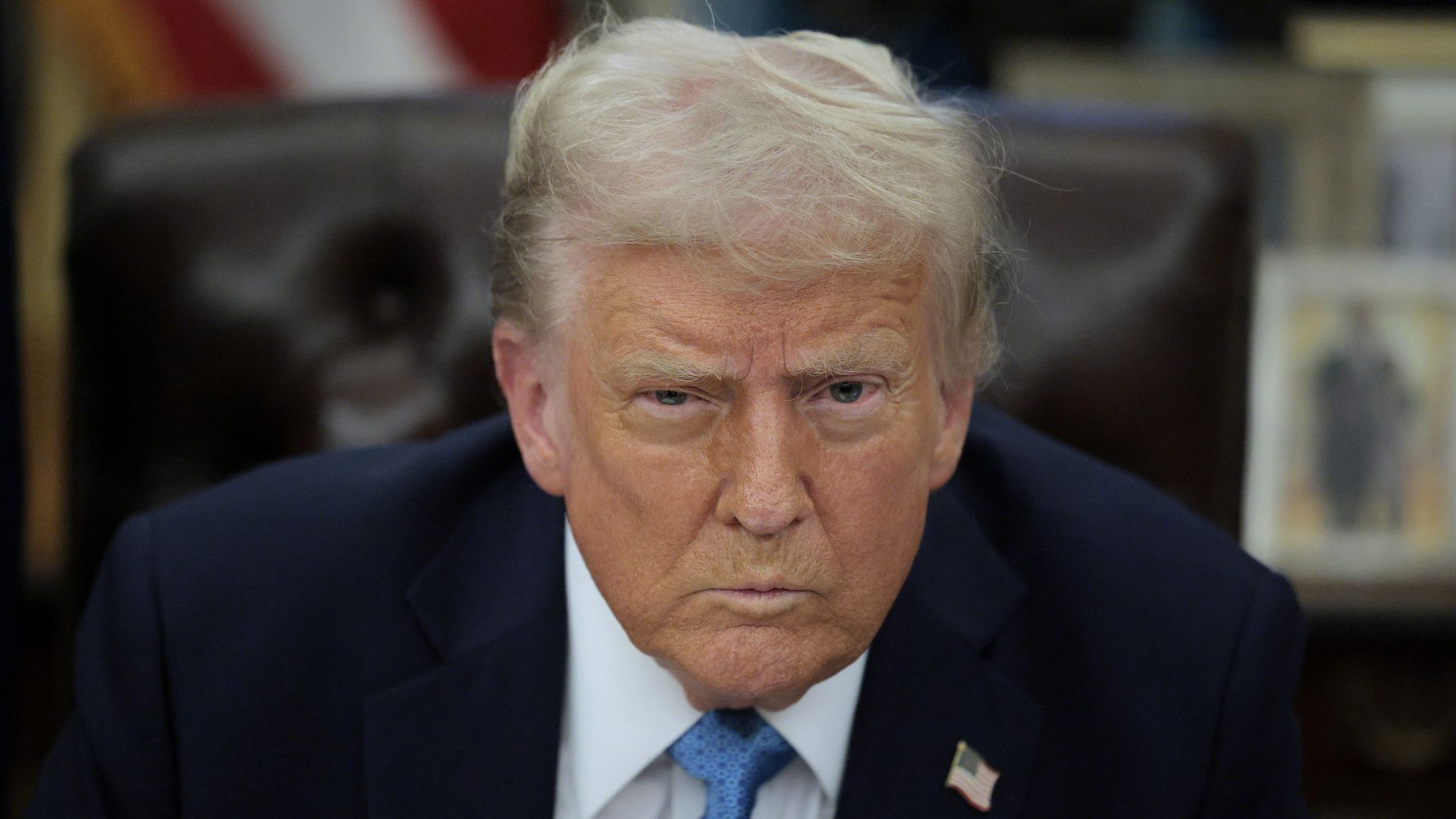 Trump looks forward from behind the resolute desk.