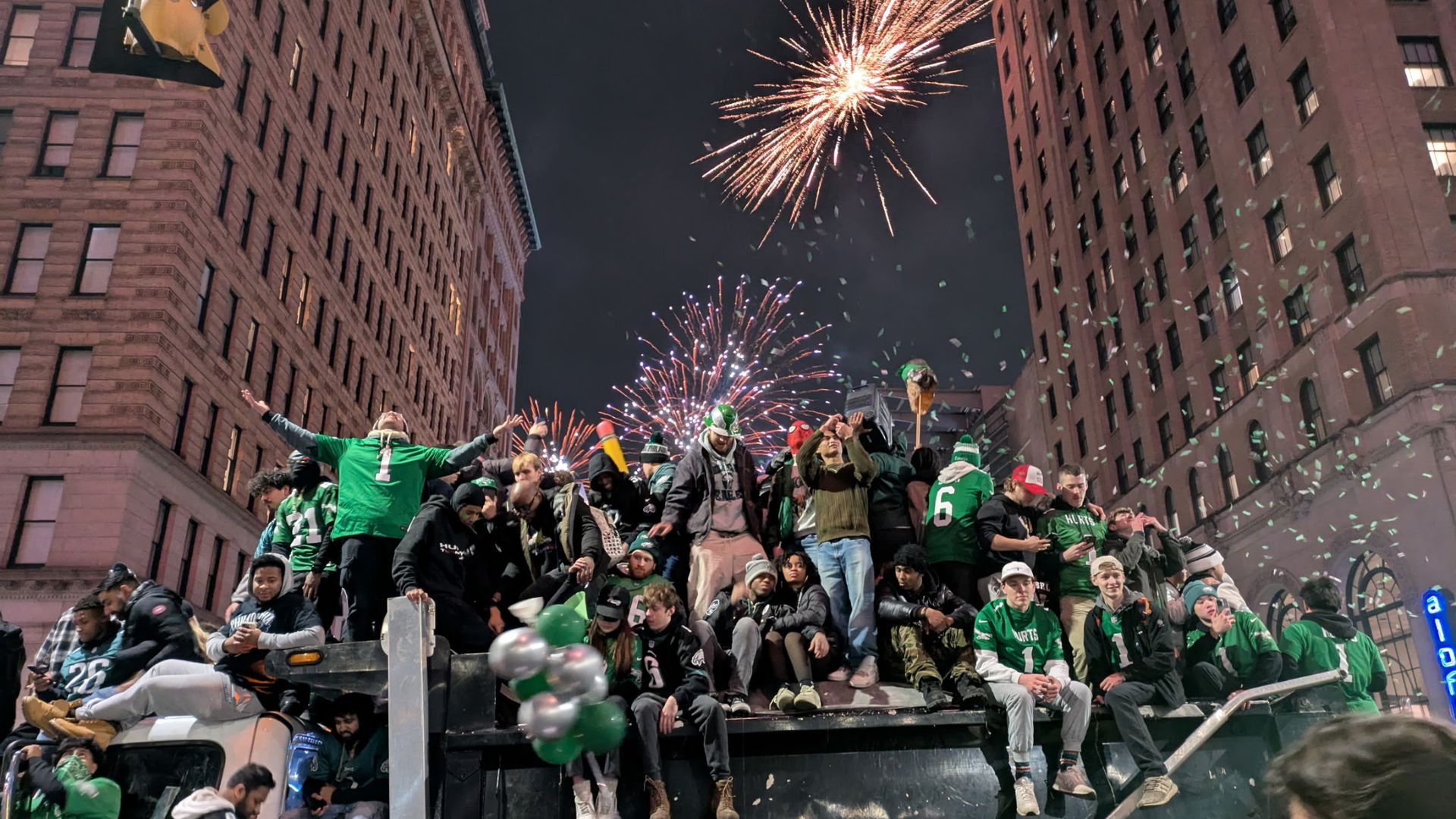 Fans celebrate with fireworks erupting behind them.