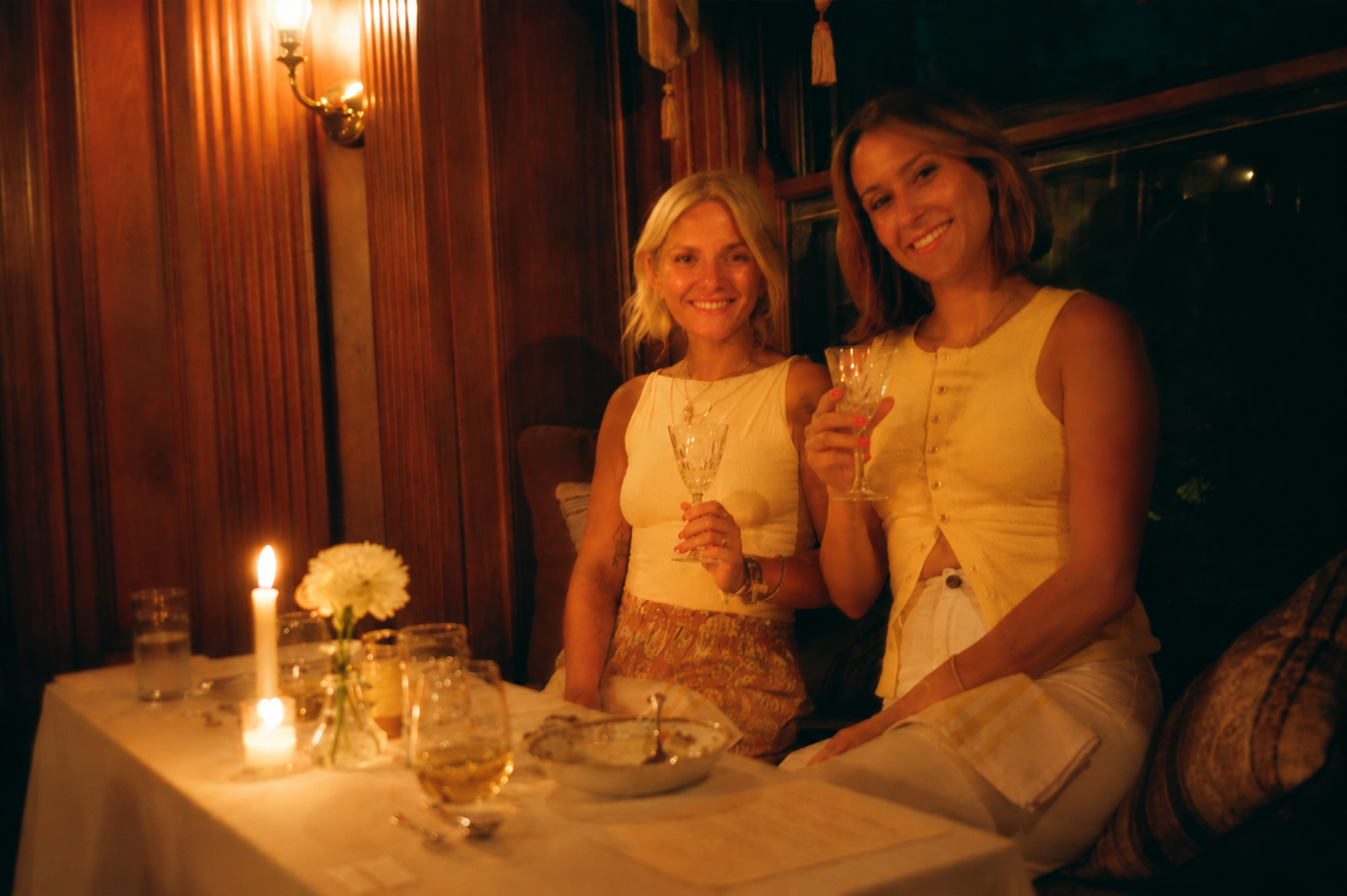 Women seated at a table drinking wine. 