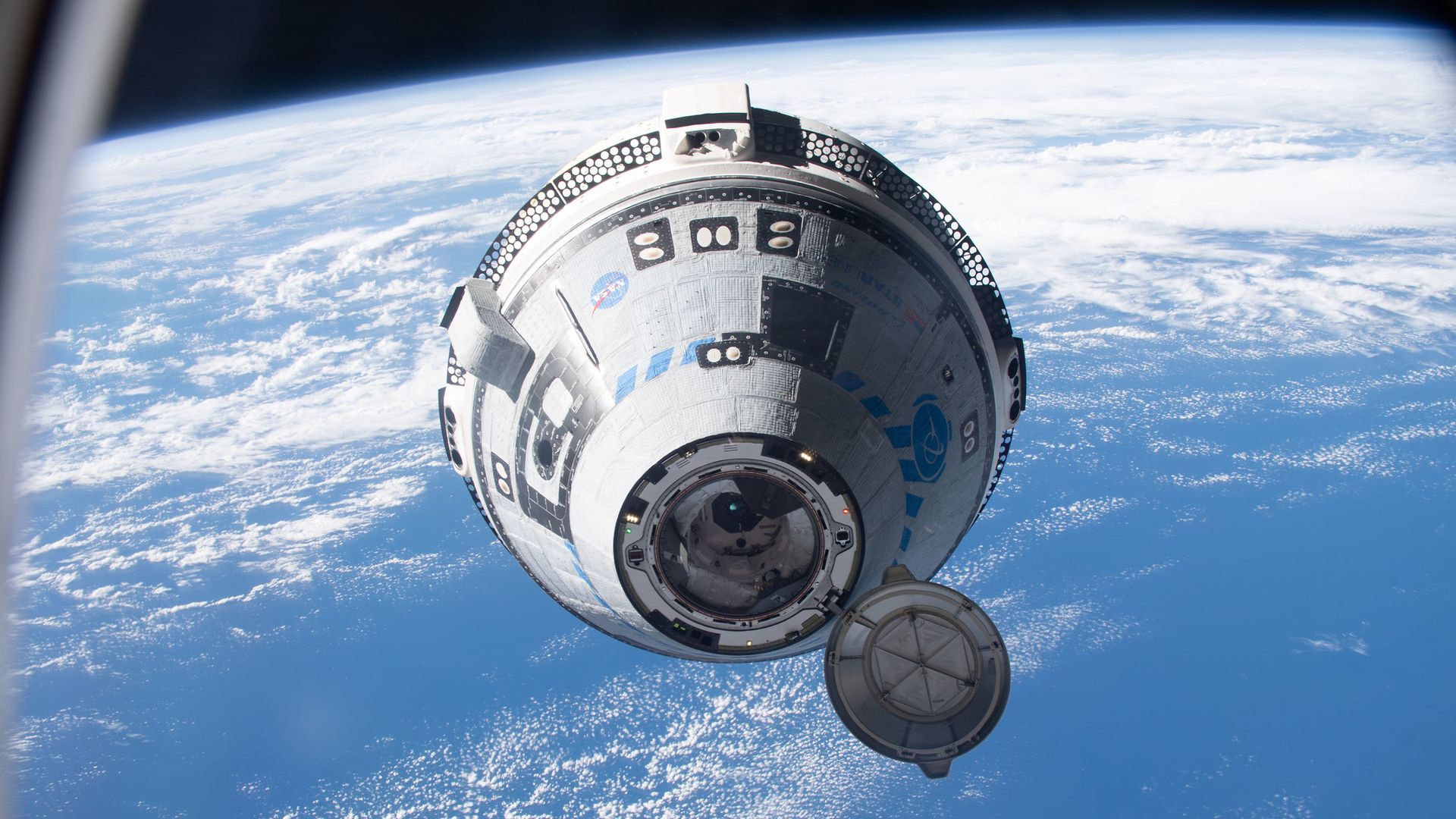 A Boeing capsule above Earth's blue oceans