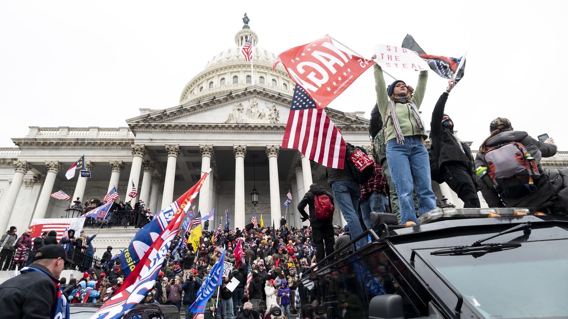 Trump supporters stand on a U.S. Capitol Police armored vehicle as others take over the steps of the Capitol