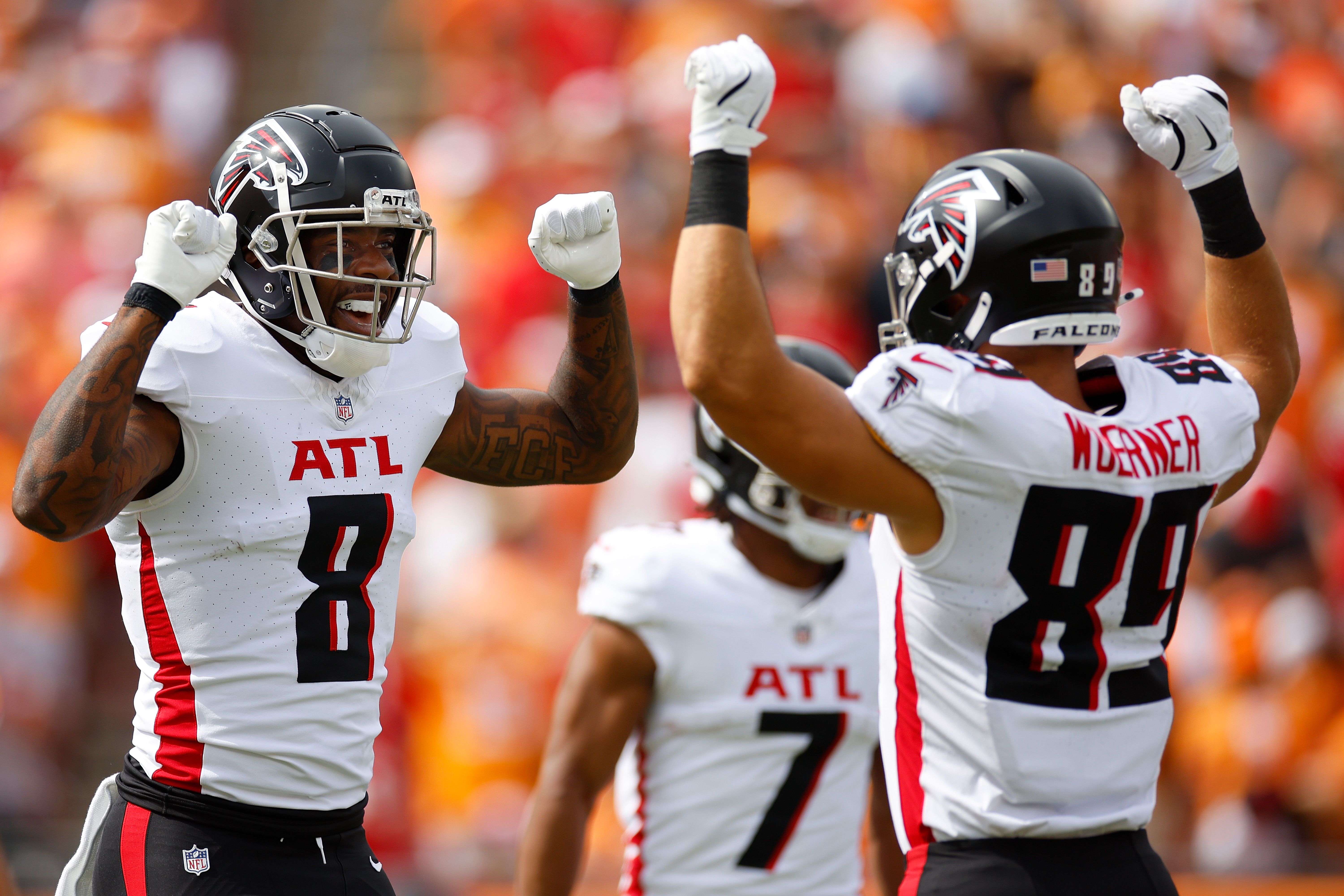 Two men in white uniforms celebrate together
