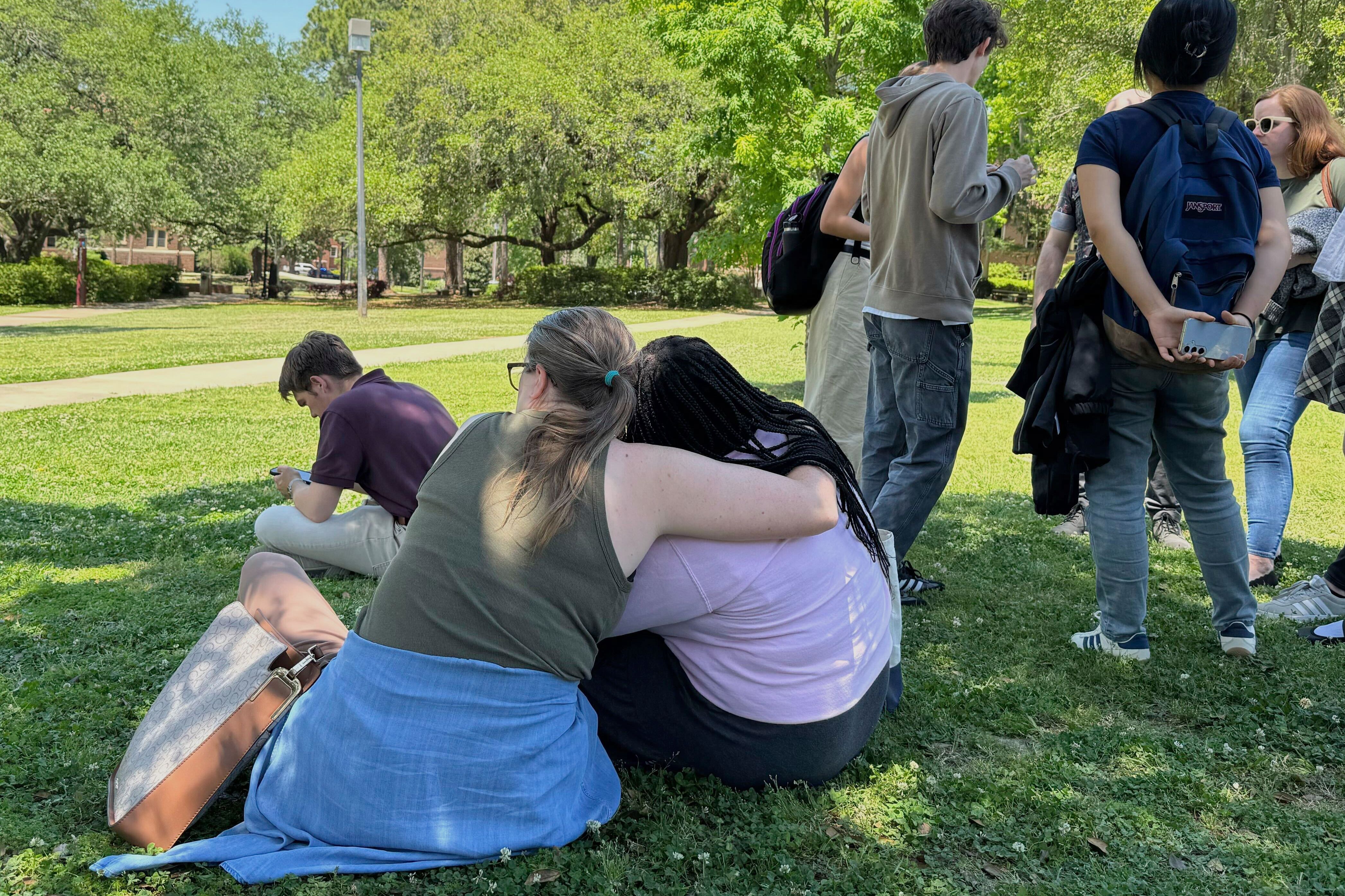 People comfort each other on Florida State University's campus in Tallahassee, where law enforcement responded to a reported active shooter incident Thursday, April 17, 2025. (AP Photo/Kate Payne)