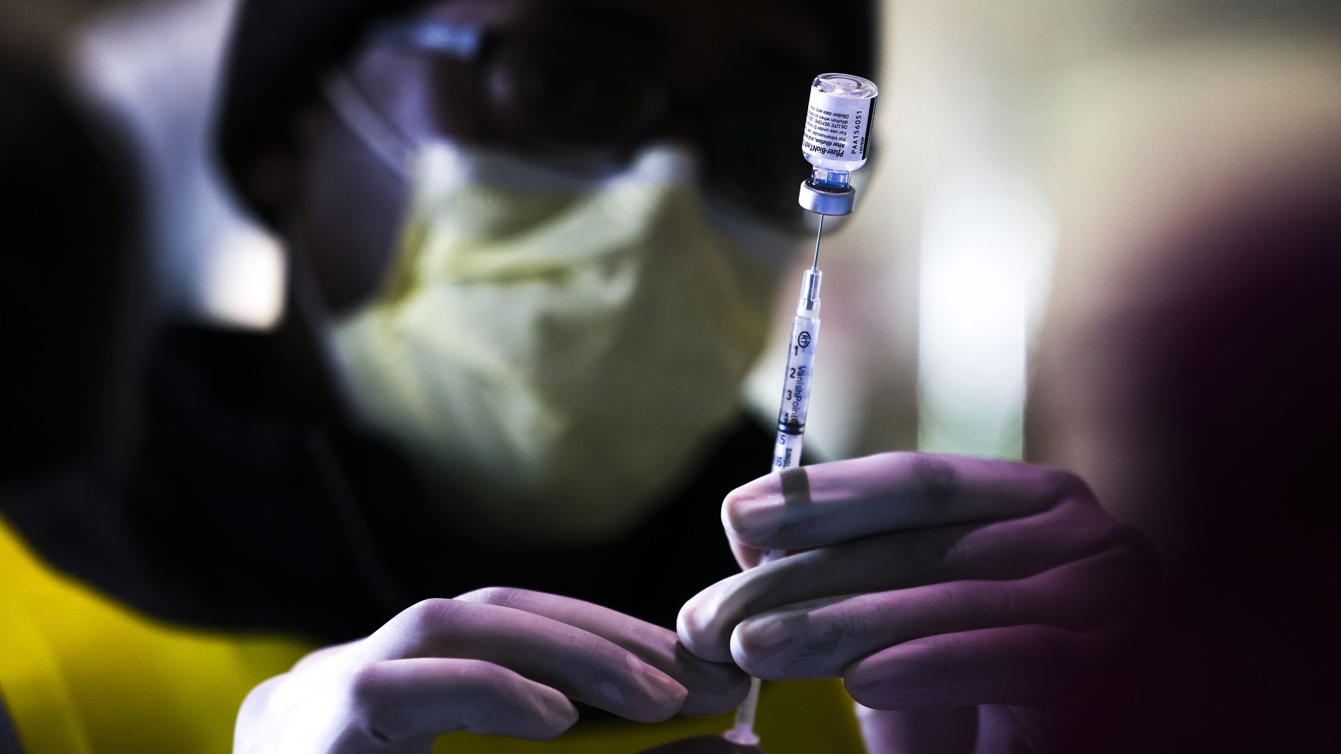  Pharmacy technicians prepare doses of the Pfizer-BioNTech vaccine at a mass COVID-19 vaccination event on January 30, 2021 in Denver, Colorado. 