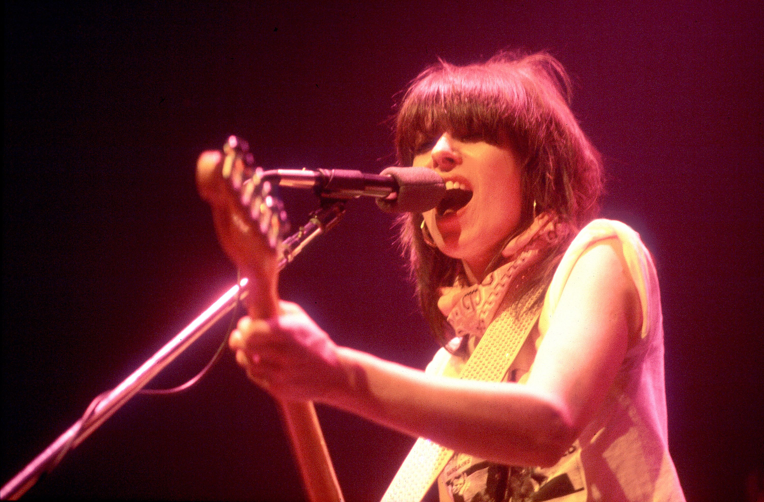Chrissie Hynde of The Pretenders plays guitar and sings on stage.