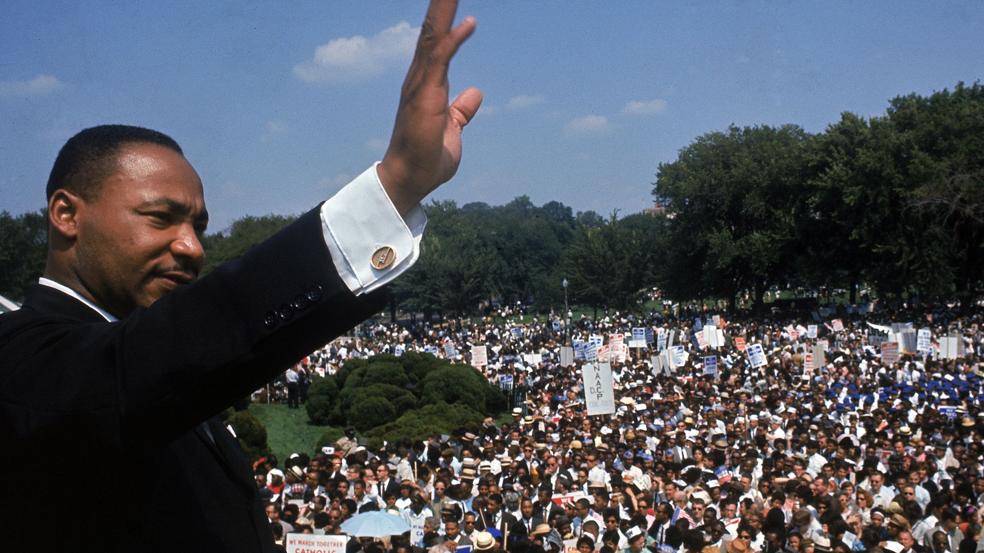 Martin Luther King, Jr. waves to a crowd