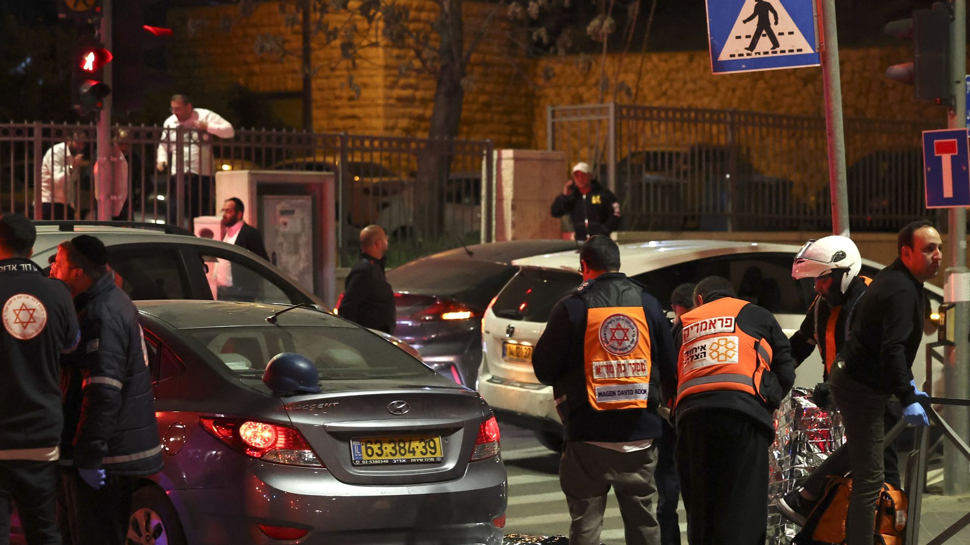 Israeli emergency service personnel and security forces stand at the scene of a shooting attack in Jerusalem.
