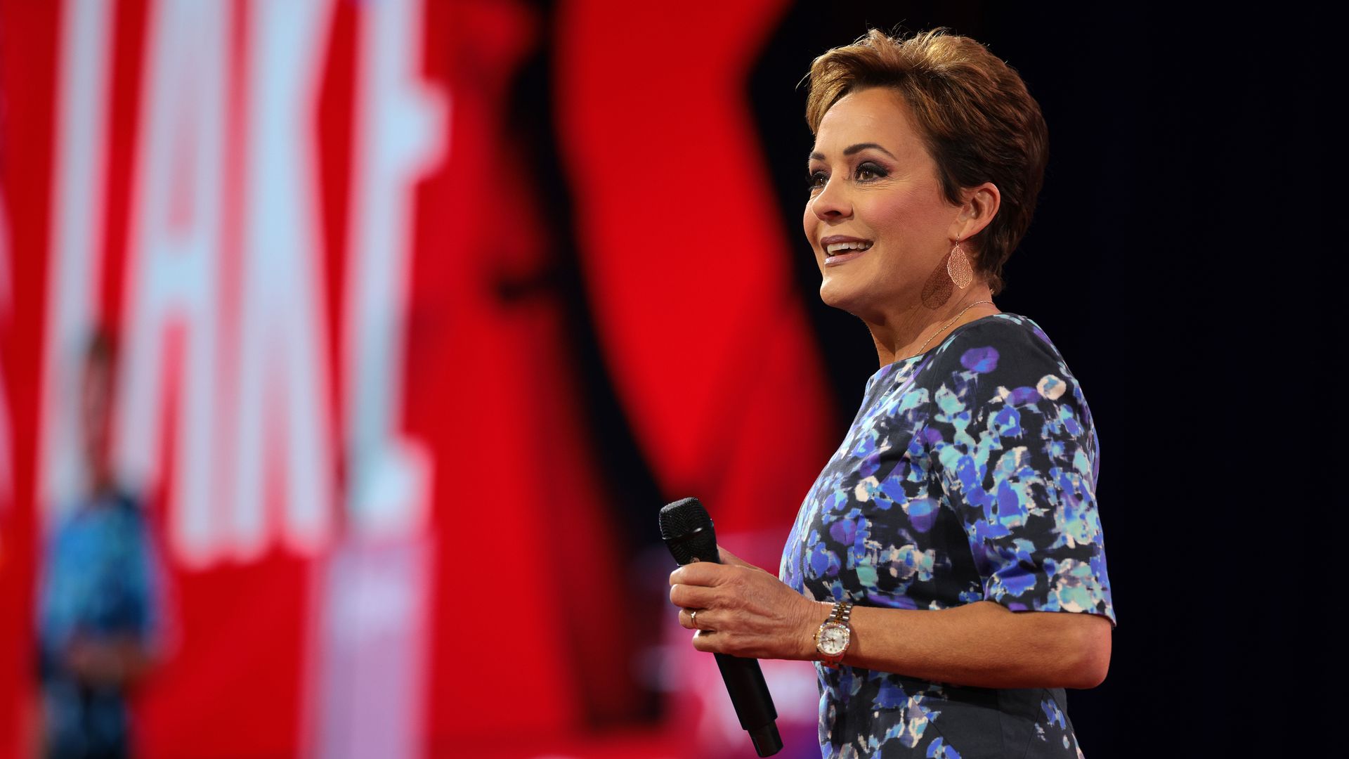A woman standing on a stage holding a microphone.