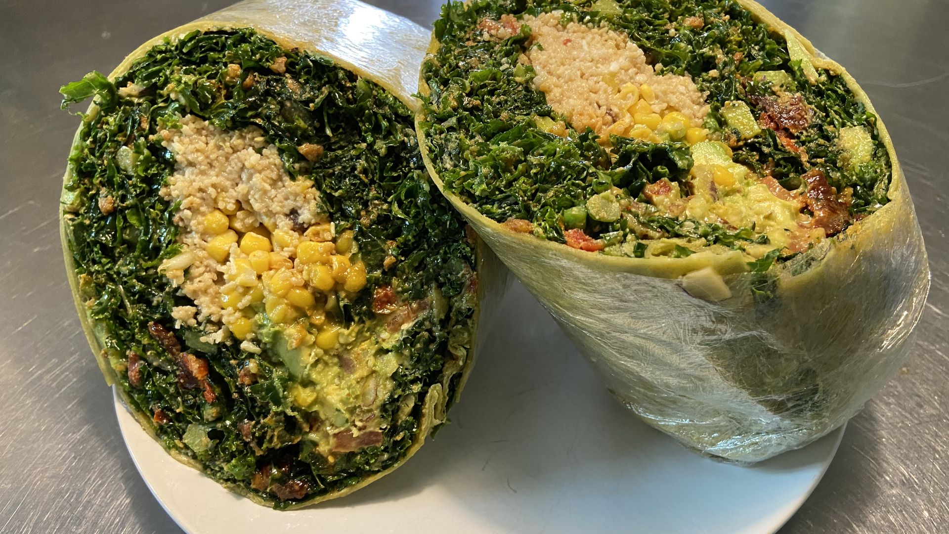 A massive spinach wrap stuffed with raw food like garlicky kale, coconut corn, spices and more