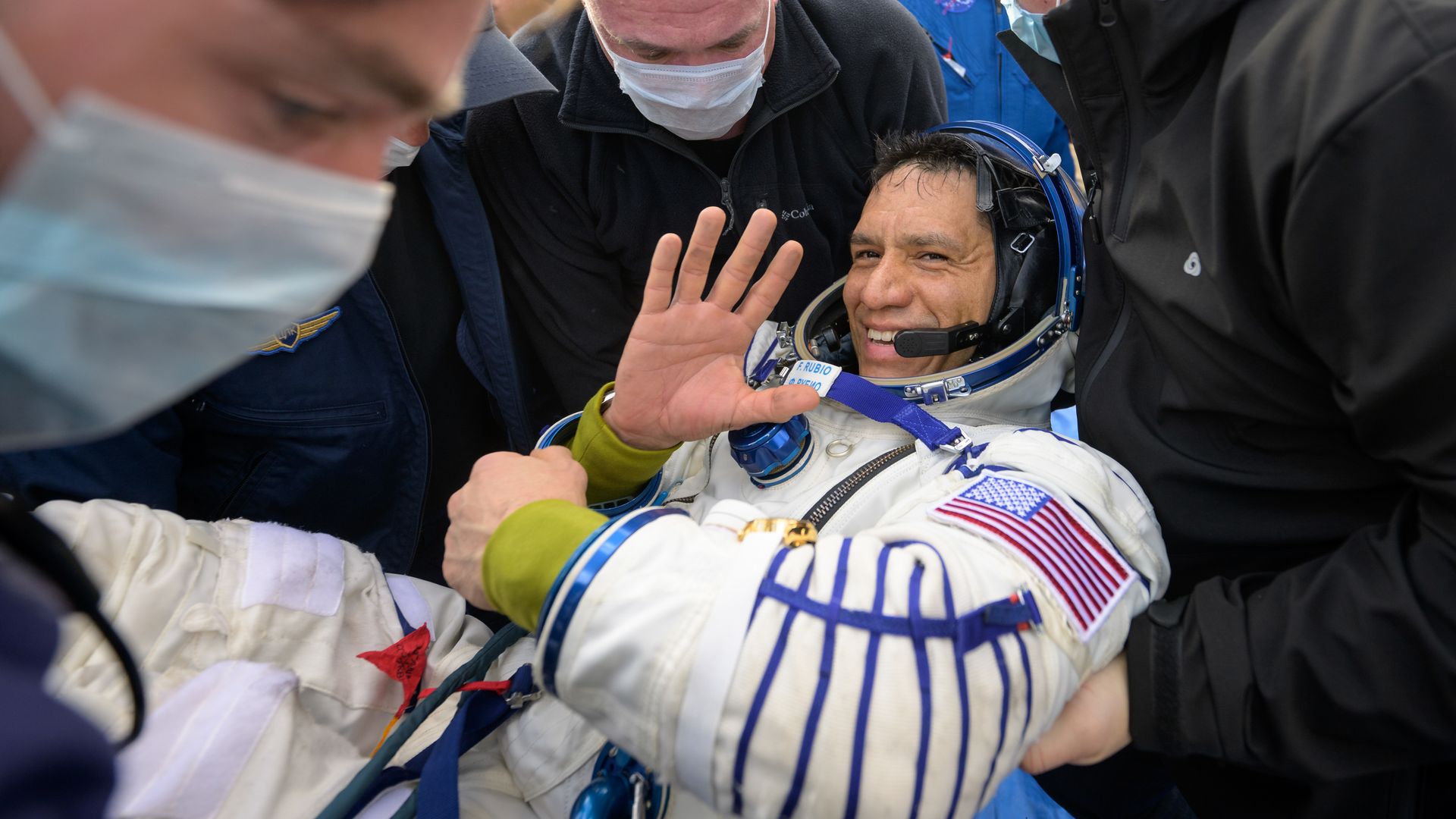 NASA astronaut Frank Rubio after landing in Kazakhstan and waving to the camera smiling while being carried to the medical tent