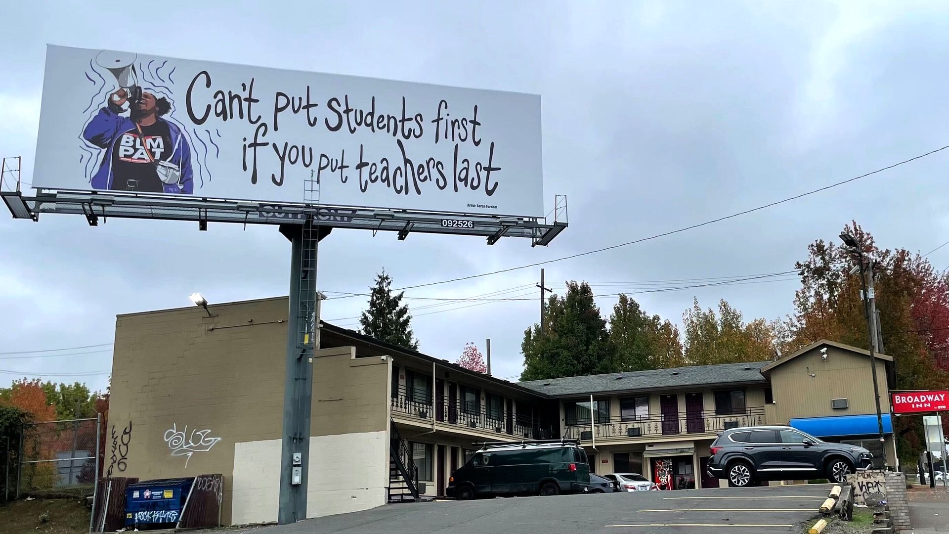 A billboard that says "Can't put students first if you put teachers last" and shows an image of the president of the Portland, Oregon teachers union speaking through a billboard.