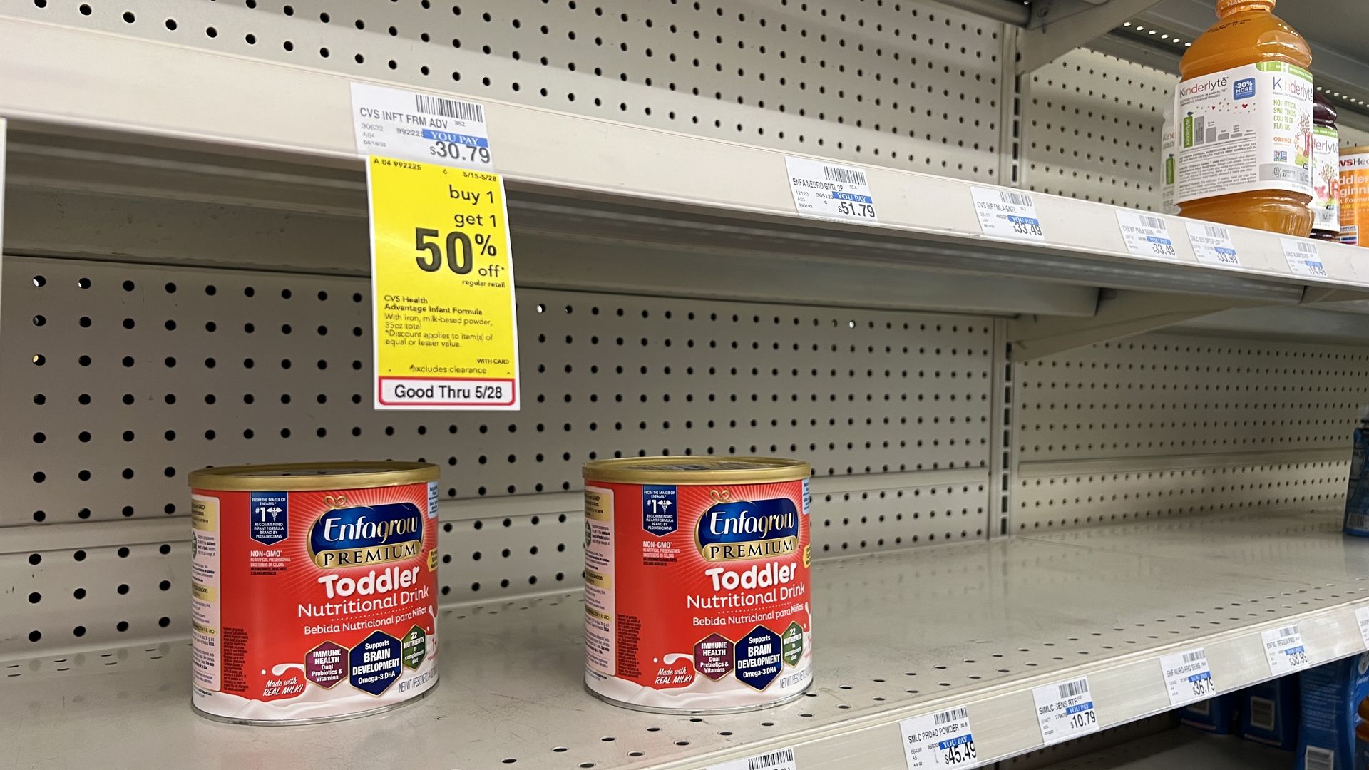 A few canisters of baby formula sit on mostly empty shelves at the store