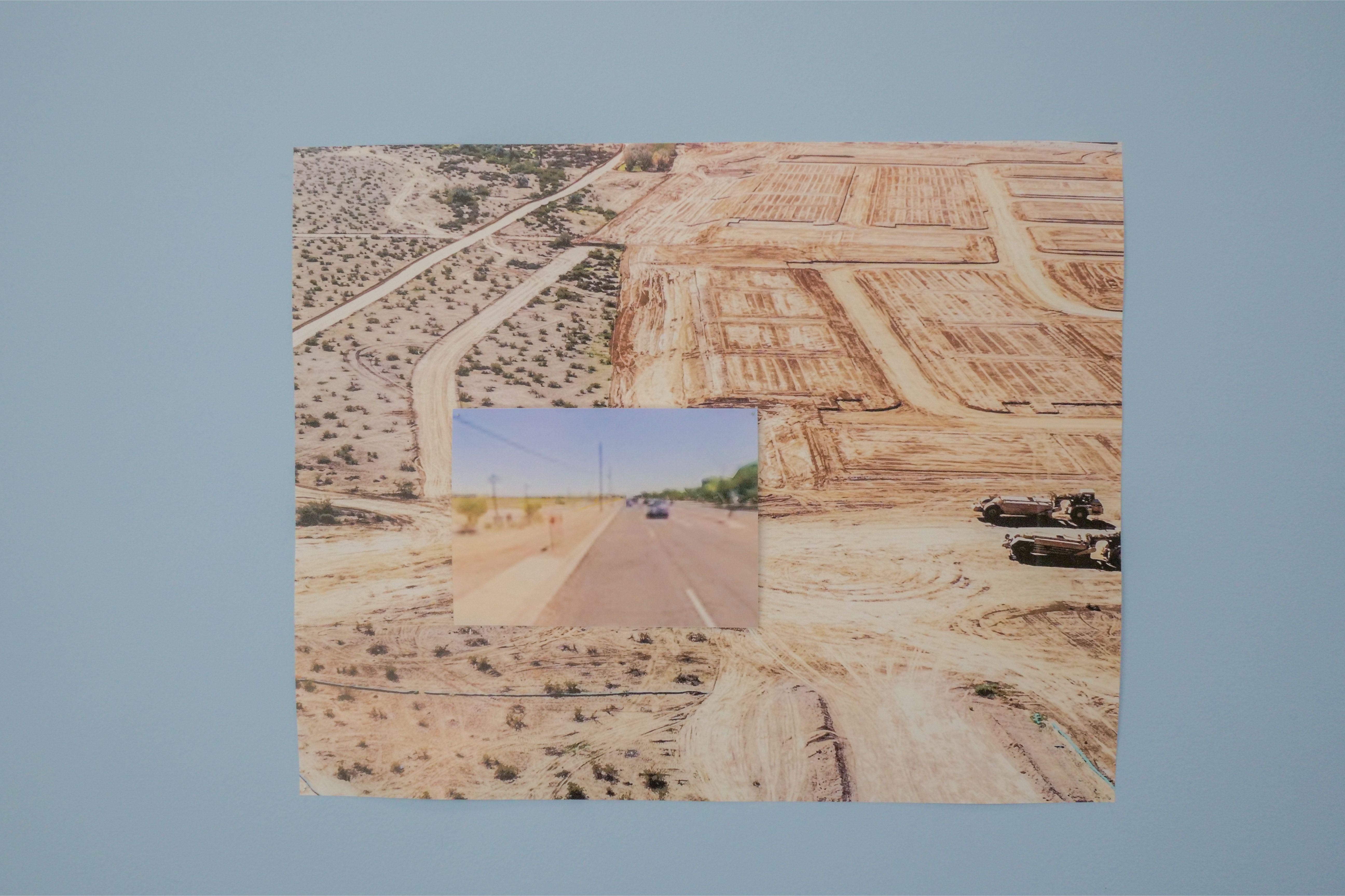 A collage of desert photos mounted on a light blue wall: tan sandy terrain with dirt roads and grid-like plots, plus smaller overlapping images at the bottom.