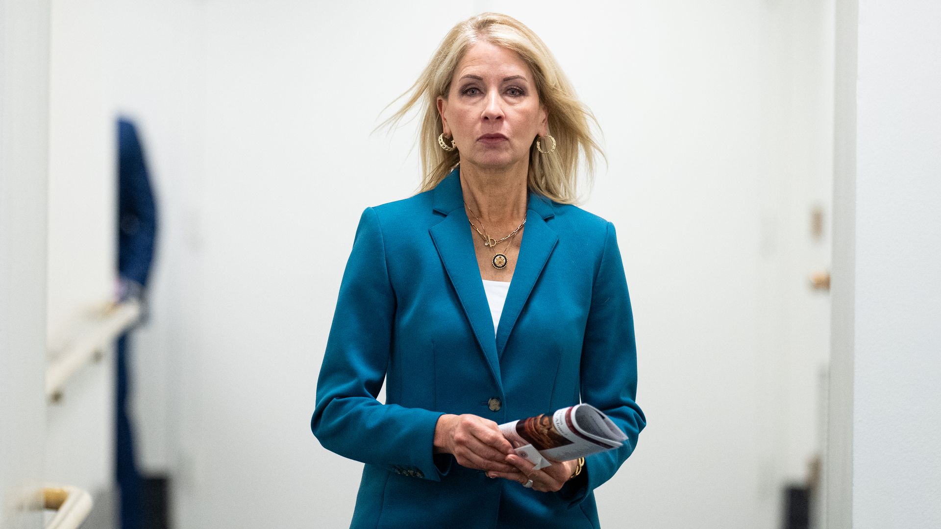 Photo of a woman walking in a hallway. 