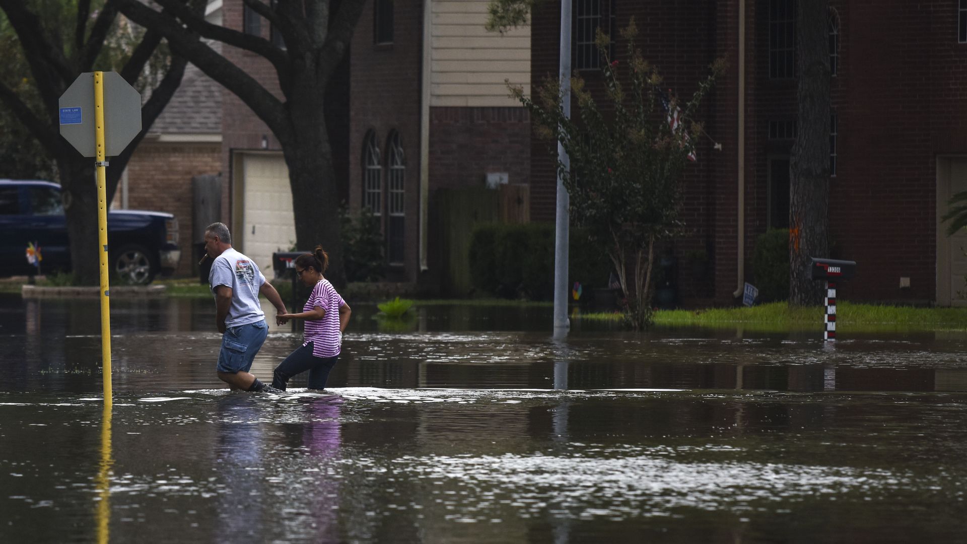 A couple walks through an inundated community in Houston after it was hit by Hurricane Harvey.