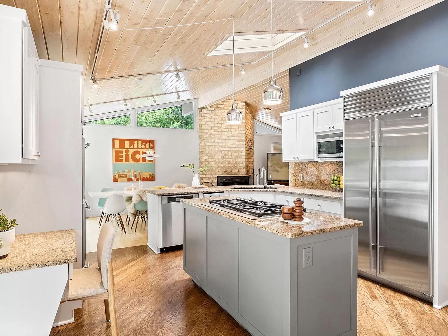 A kitchen with vaulted ceilings, a kitchen island and stainless steel appliances.