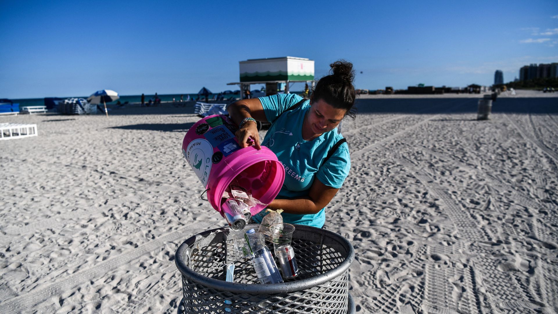 Sophie Ringel, founder of the nonprofit organization "Clean Miami Beach," empties trash left on the beach by visitors in a dustbin, in Miami Beach