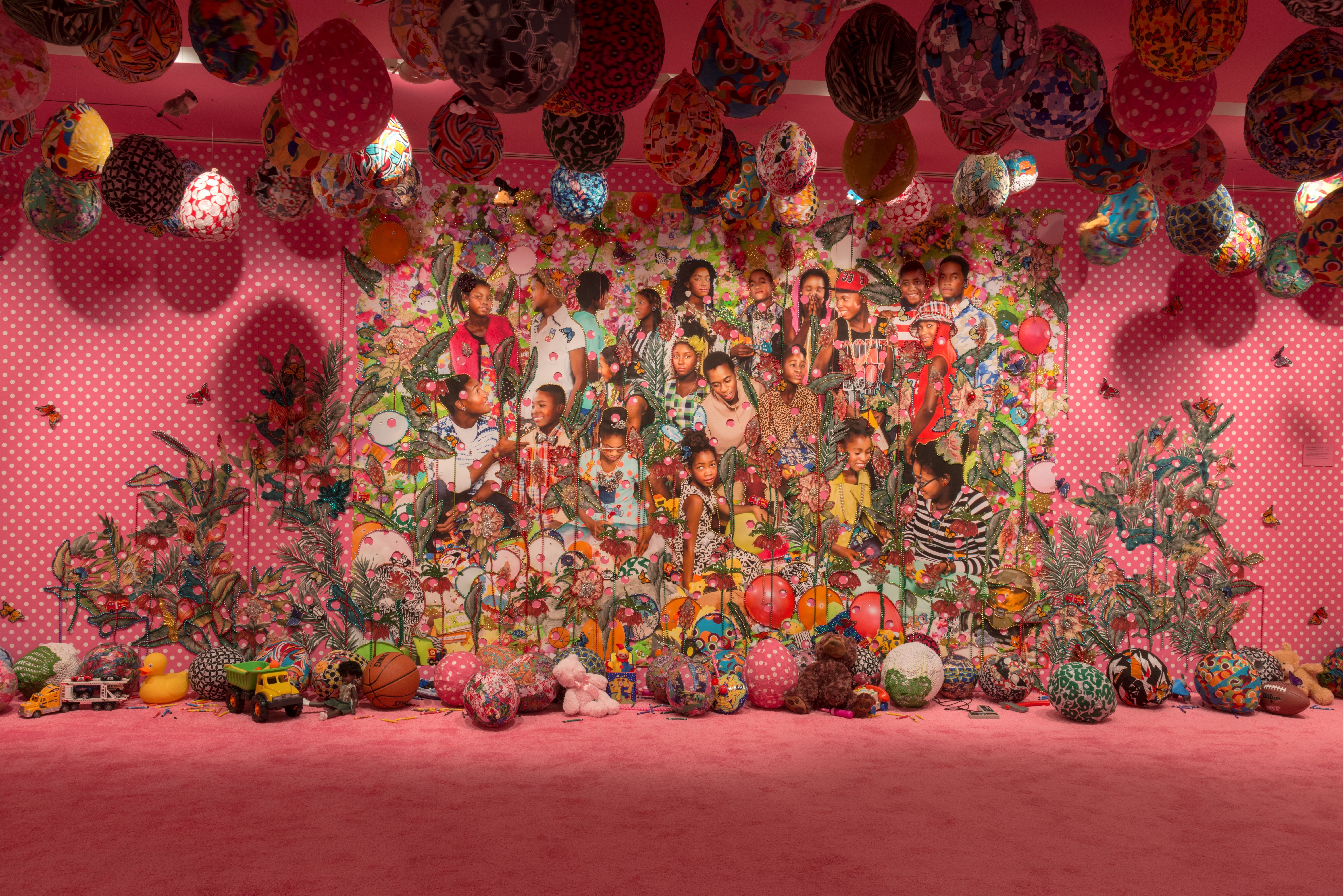 A bright pink piece of art with a bunch of colorful eggs 