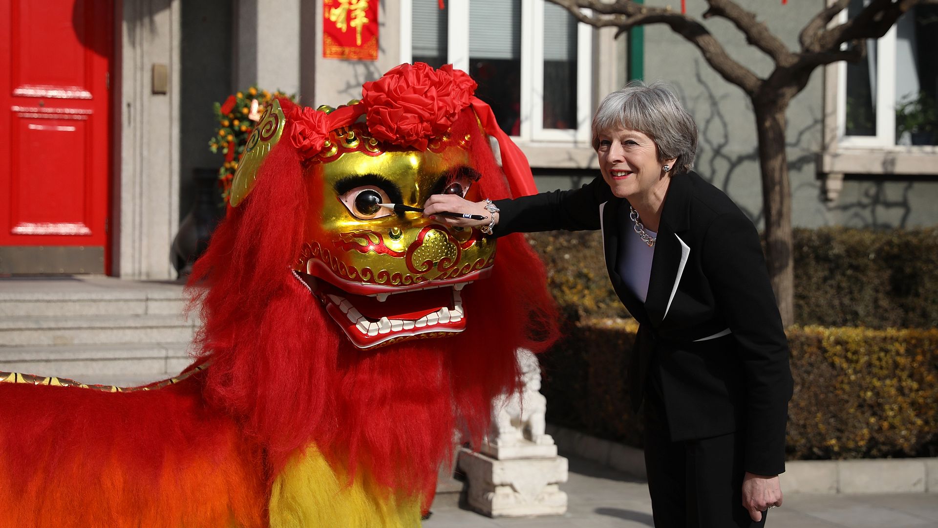 Theresa May touches a Chinese dragon