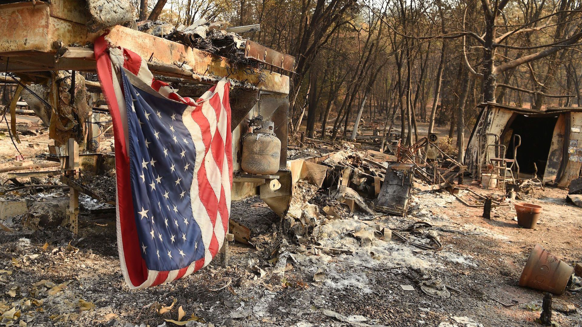 An American flag hangs at a burned out mobile home park