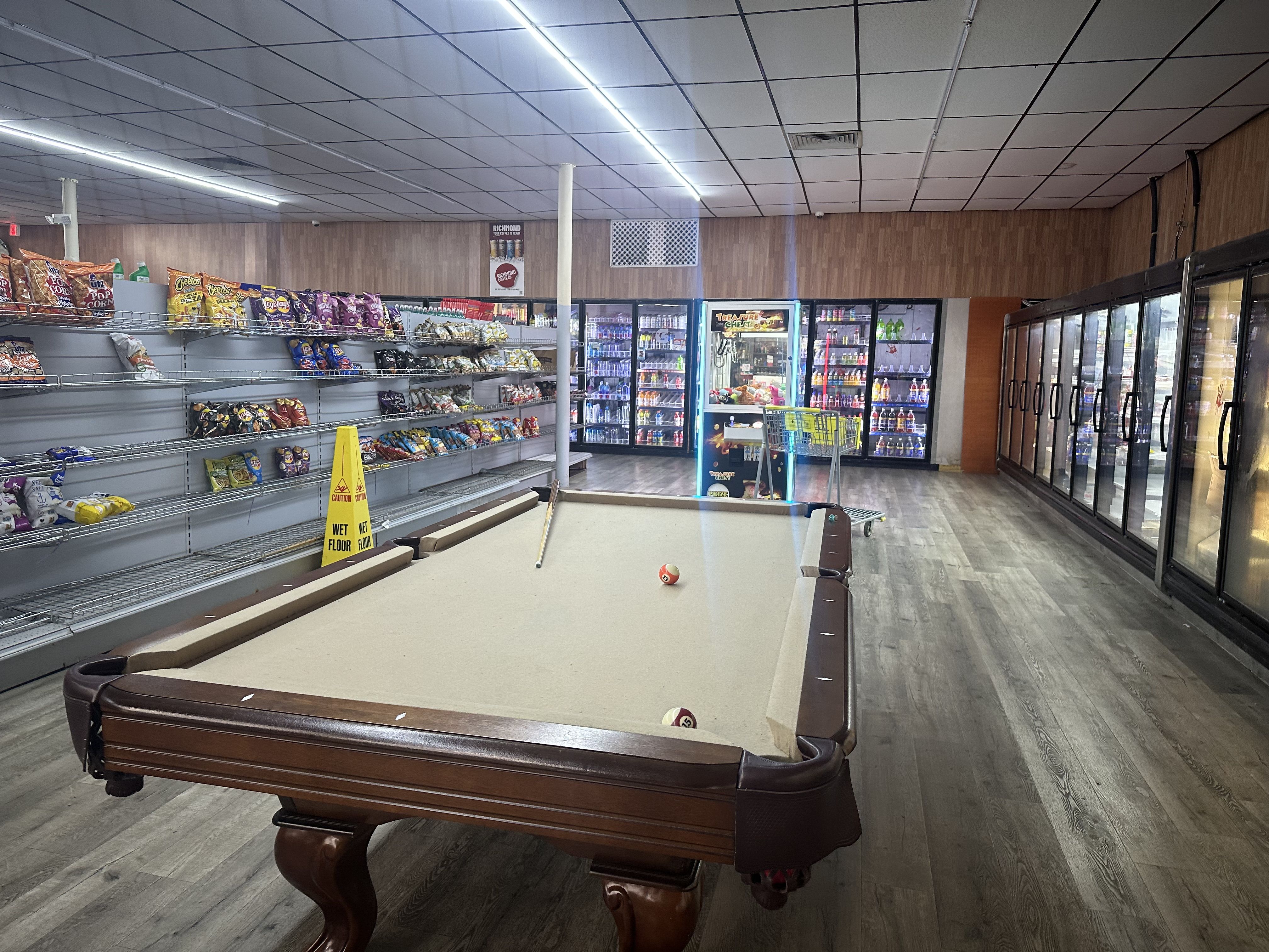 A pool table in the middle of a convenience store 