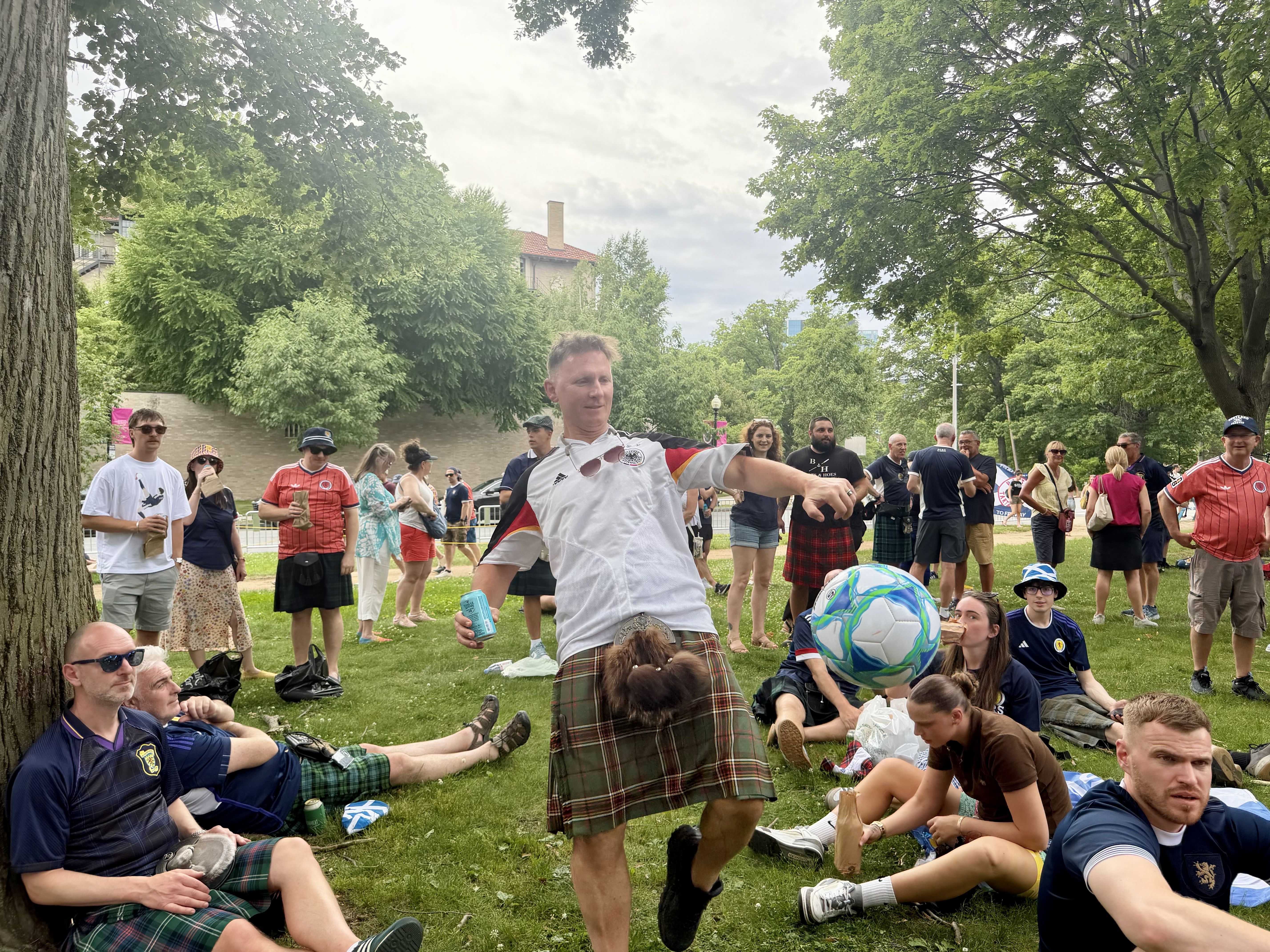 Brandon Murphy, a Scotland fan in a kilt, kicks a soccer ball toward the crowd of fans playing on Evans Way in Boston on Sunday, June 14, 2026.